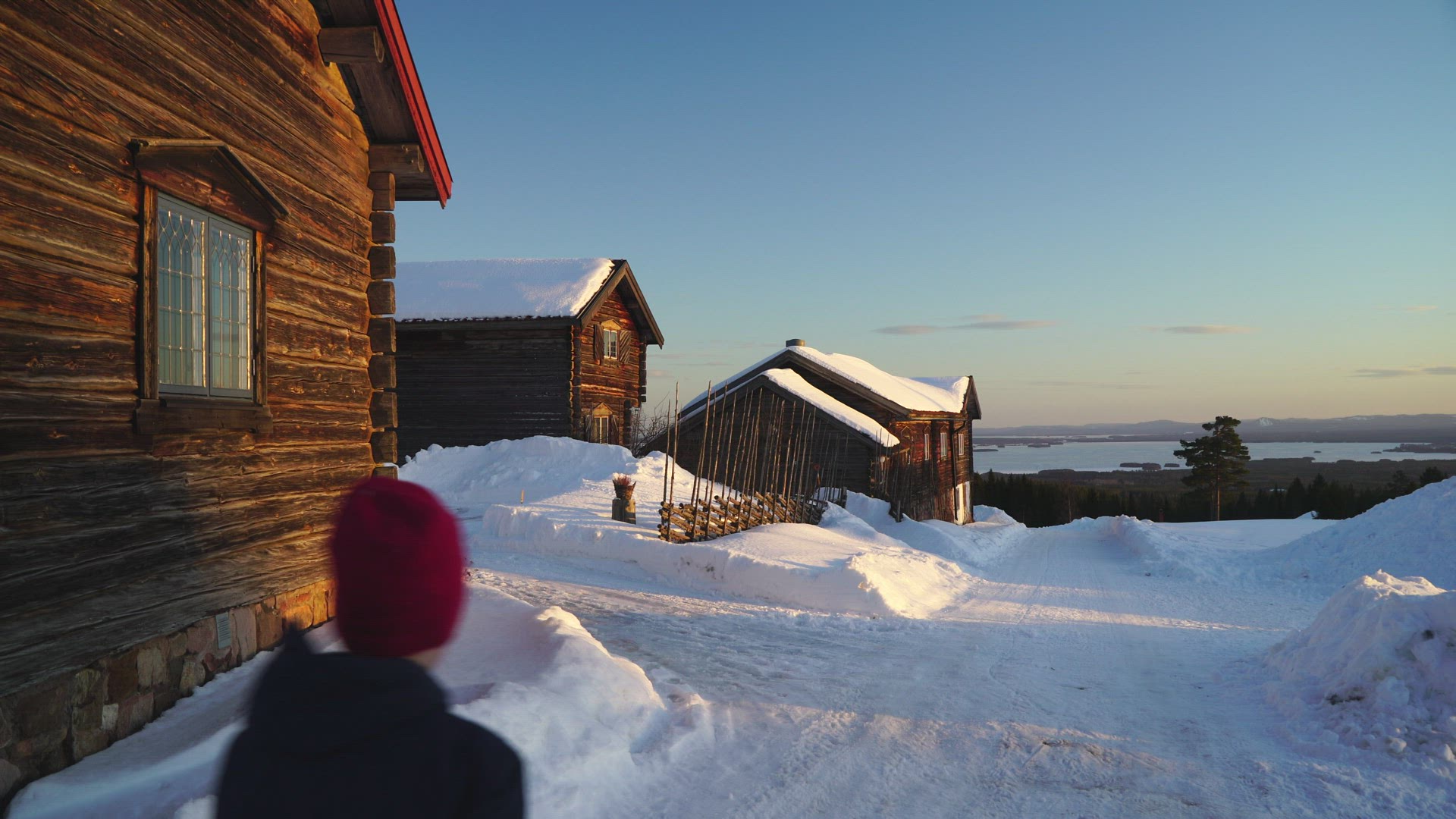 boy walking on wintry road among old houses in Fryksås