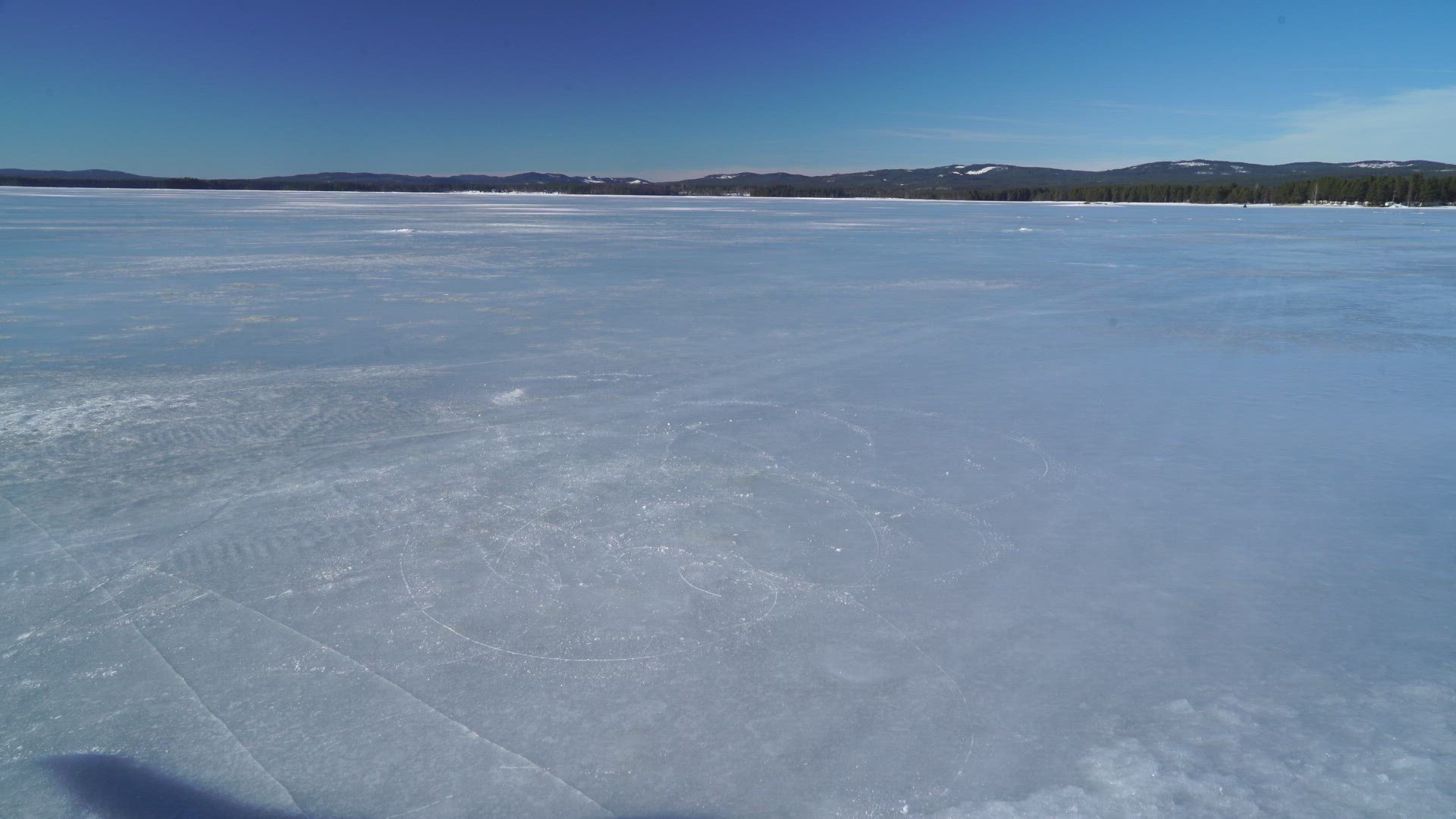 boy skating on frozen lake - doing figures - practising