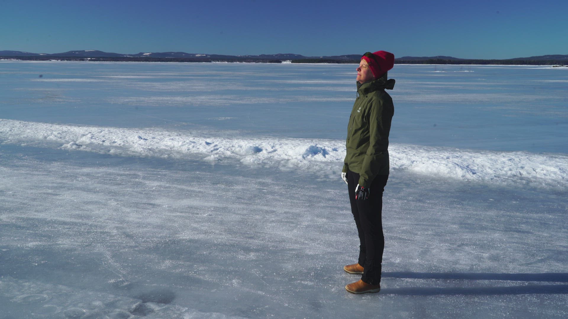 woman standing on frozen lake - basking in sun