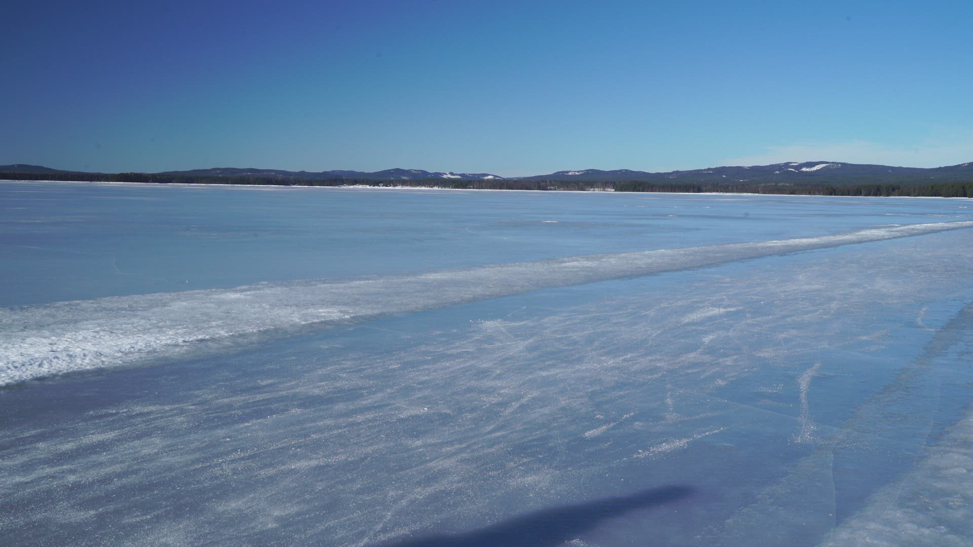 woman walking on frozen lake - boy skating