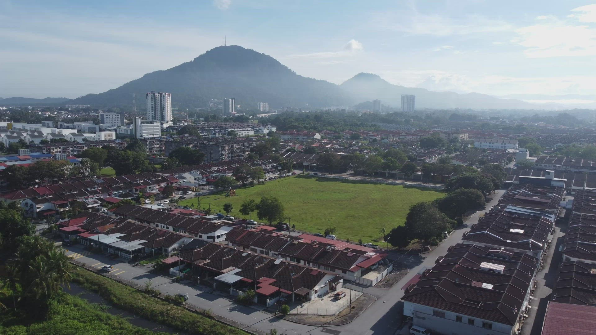 Aerial view fly over green football field in suburban