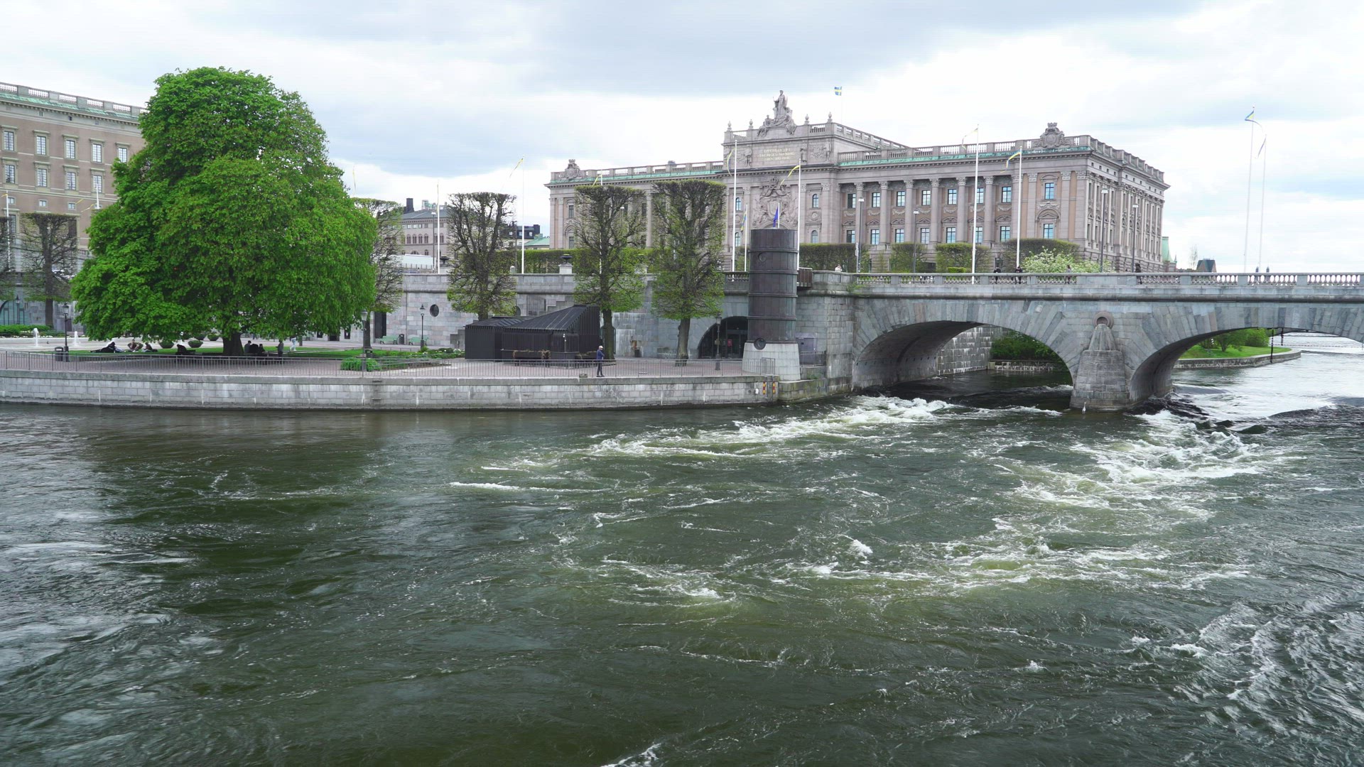 view over streaming water in central stockholm - parliament building in background