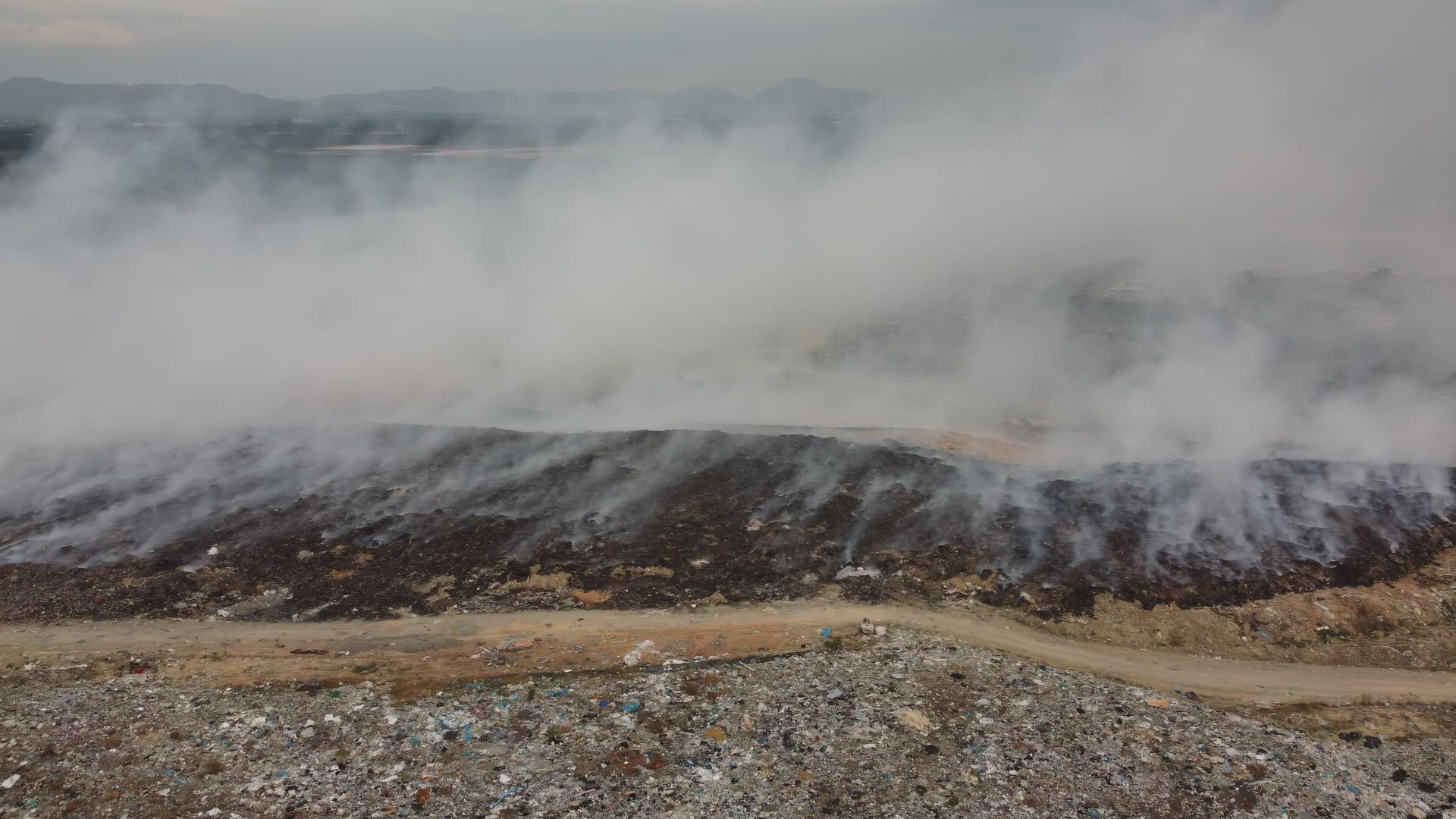 Aerial sliding over rubbish dump site burning