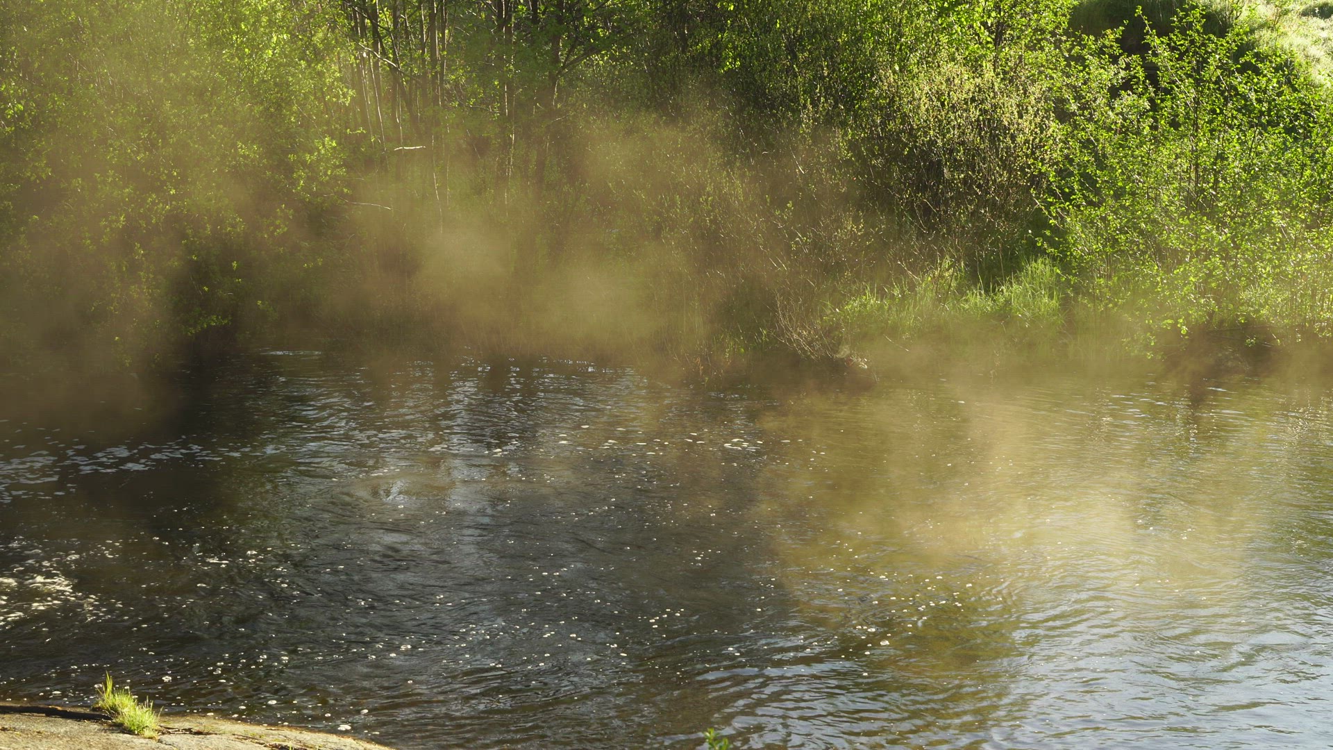 fog lightens over water in streaming river
