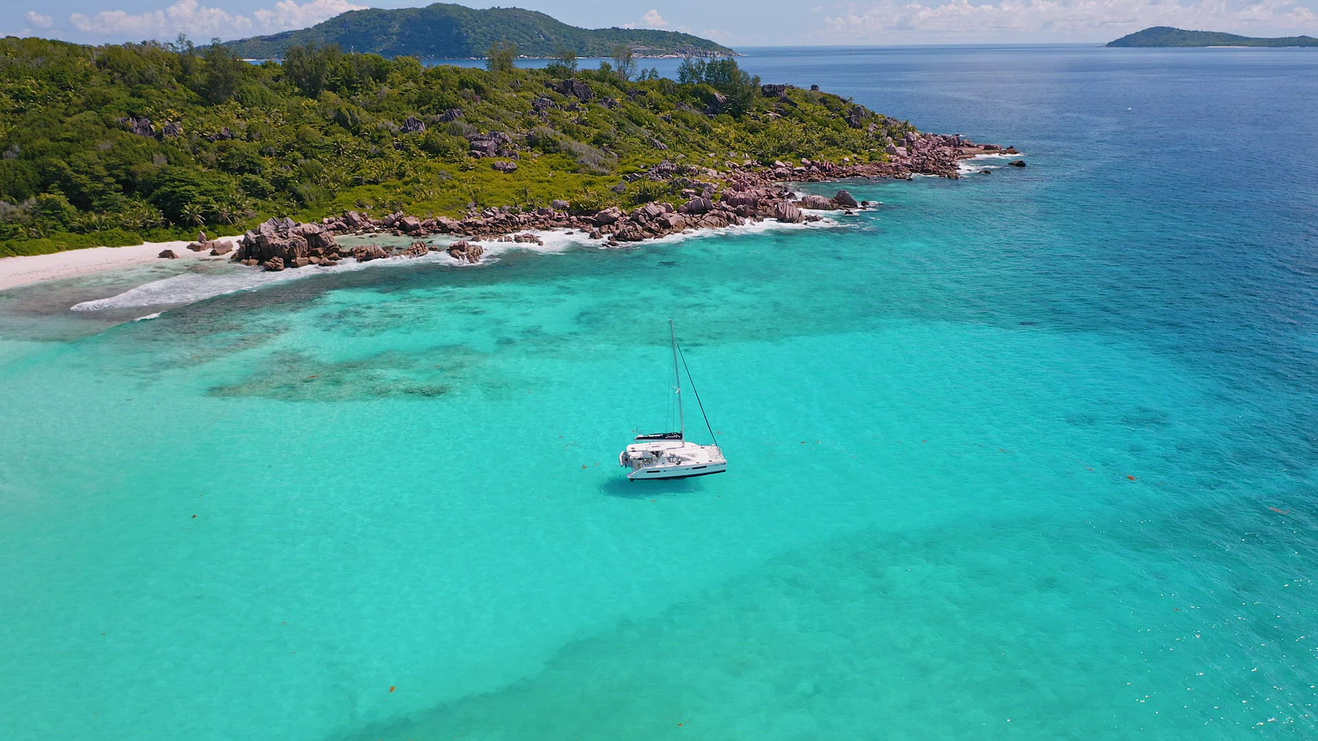 Seychelles, La Digue Island. Drone circle footage of white yachts in blue ocean lagoon. Luxury summe