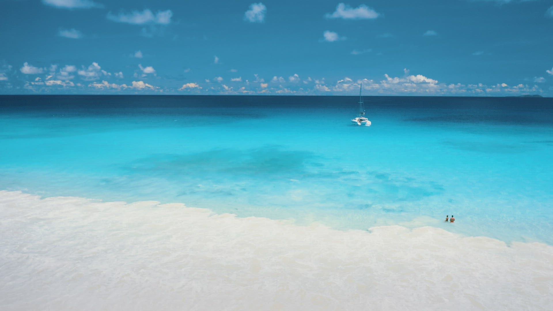 4K drone view of couple tourists relaxing in turquoise crystal clear ocean water on tropical paradis