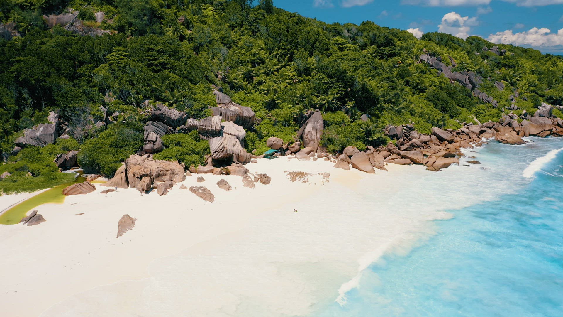 Petite Anse, La Digue, Seychelles. 4K drone circle flight over turquoise crystal clear ocean water n