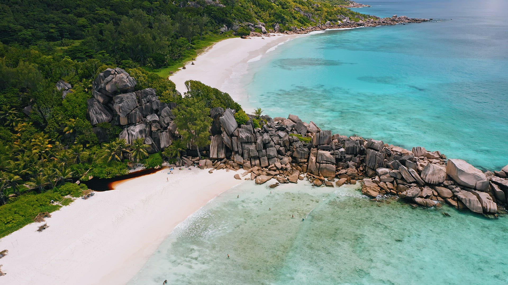 4K drone aerial circle flight above granite rocks and azure crystal clear ocean water of picturesque