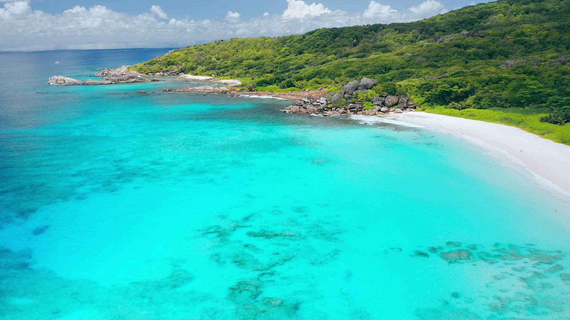 4K drone forward flight over turquoise crystal clear ocean water near to tropical paradise beach wit