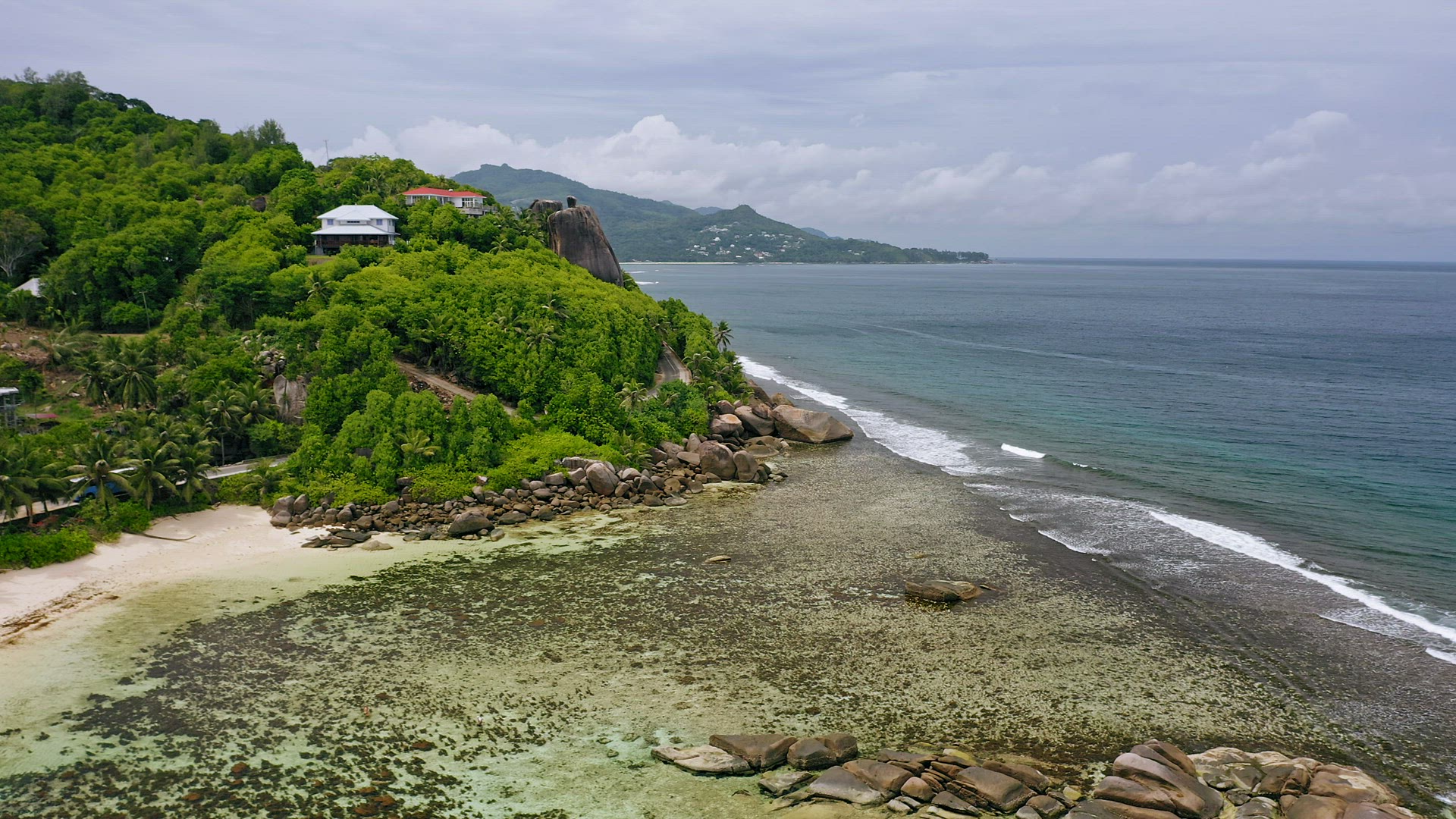 Aerial view of beautiful Mahe island coastline with tropical beaches, shallow water and rainforest. 