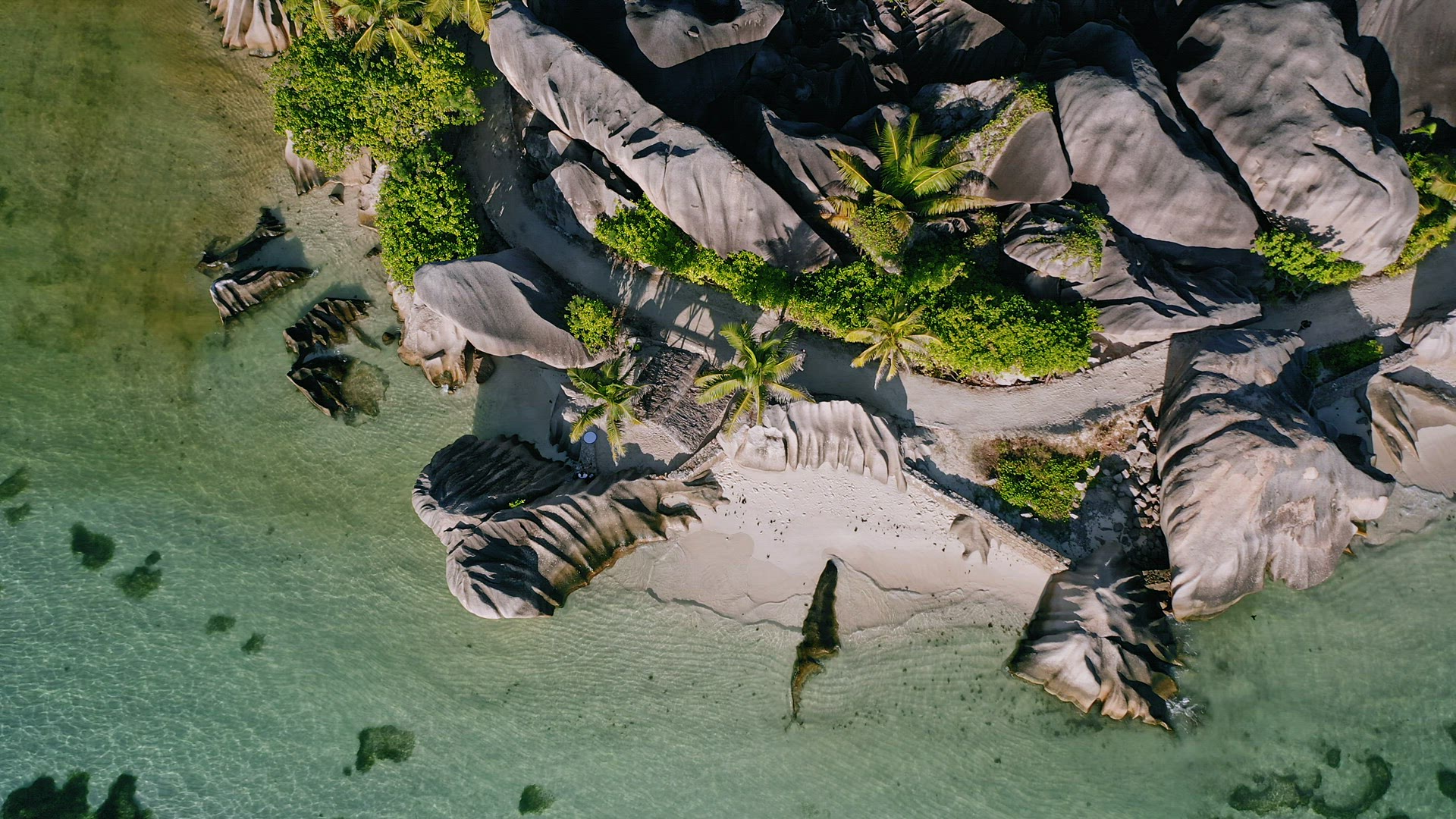 Aerial hover down footage of well known Anse Source d'Argent tropical beach at sunny day bright ligh