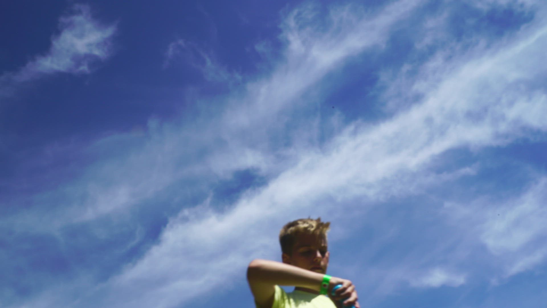 boy making soap bubbles - blue sky background