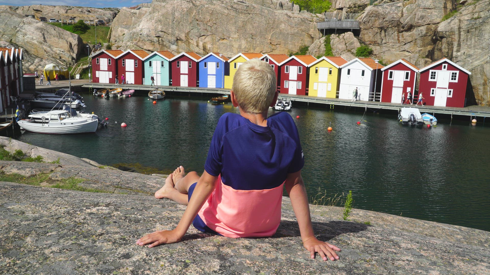 boy sitting on cliff watching landmarks in smögen bohuslän