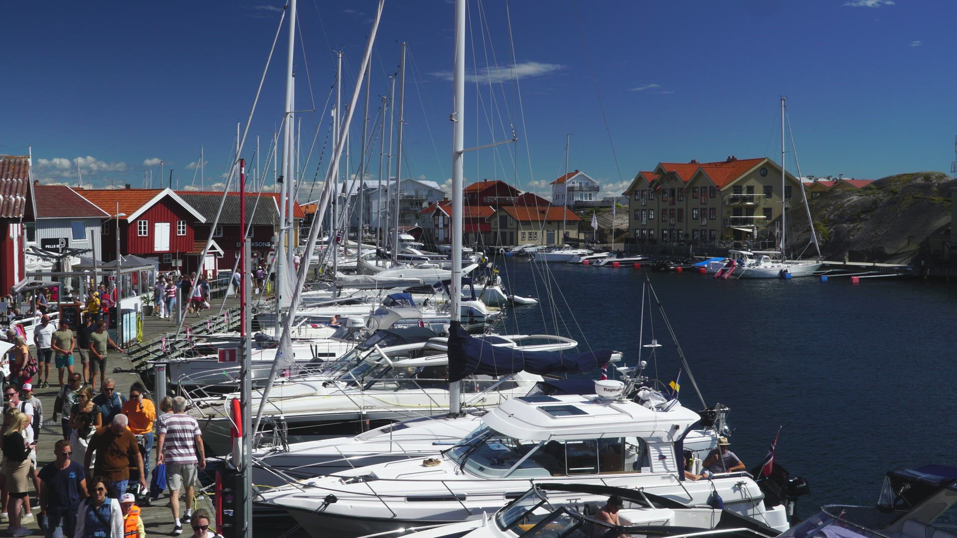 Smögen in bohuslän   - sailong boats and people walking on jetty