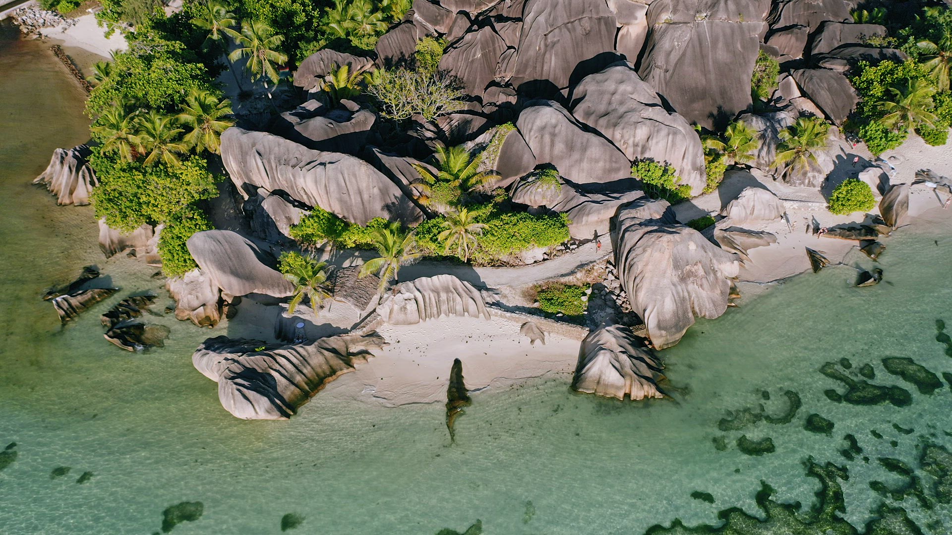 Aerial hover down footage of well known Anse Source d'Argent tropical beach at sunny day bright ligh