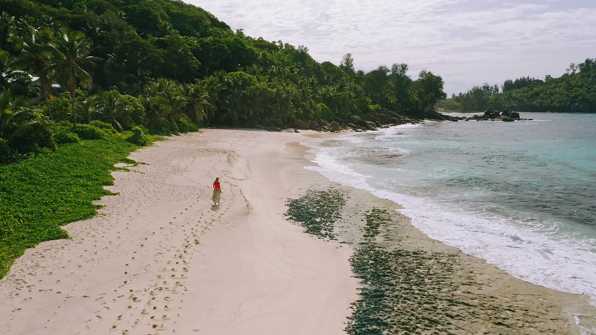 Young woman on the paradise Anse Bazarca beach. Aerial footage of tanned girl on beautiful Mahe isla