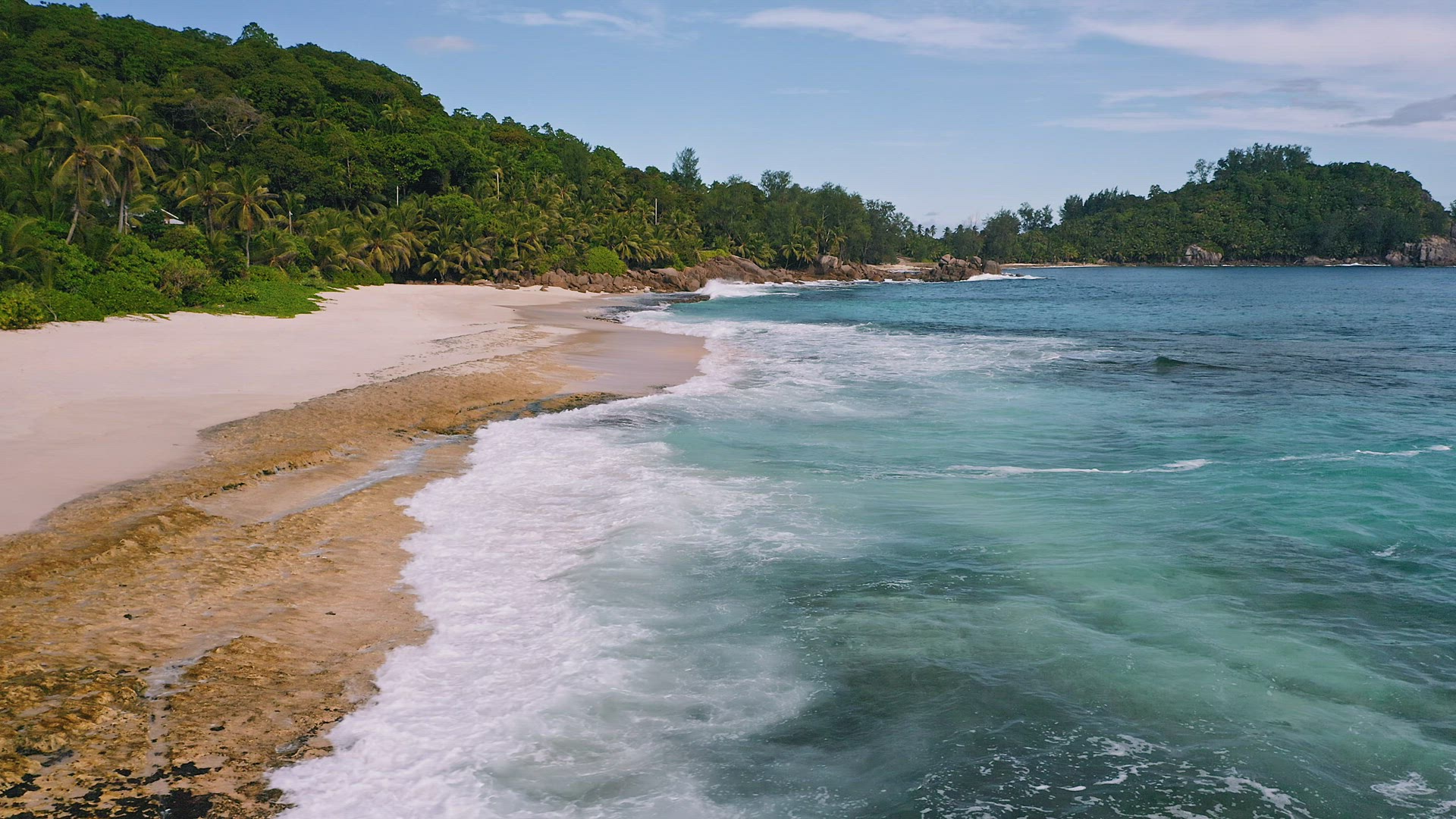 Mahe island, Seychelles. Aerial view of ocean waves rolling to sandy tropical beach
