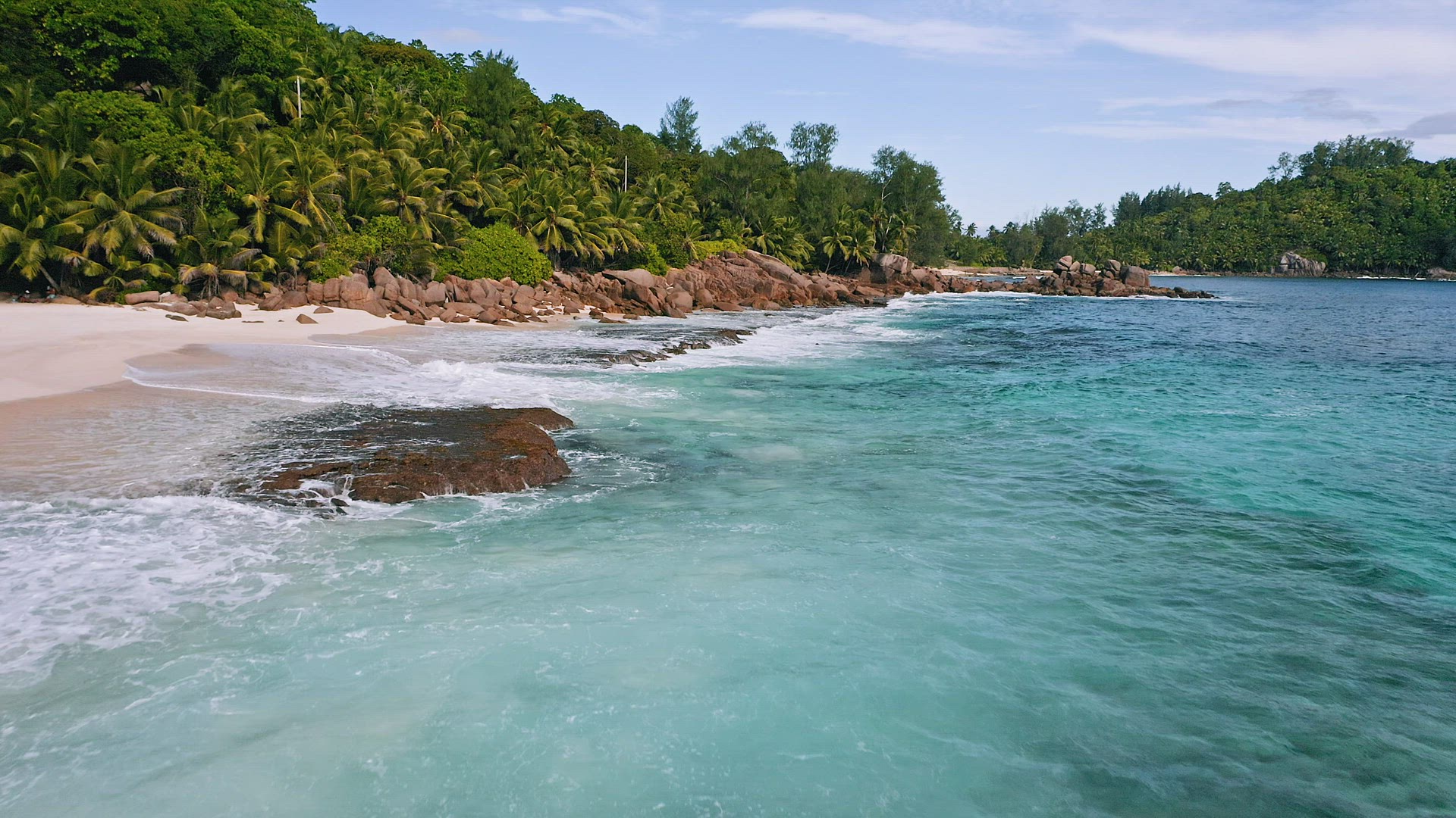 Mahe island, Seychelles. Aerial view of exotic sandy beach with ocean waves and palm trees. Lifestyl