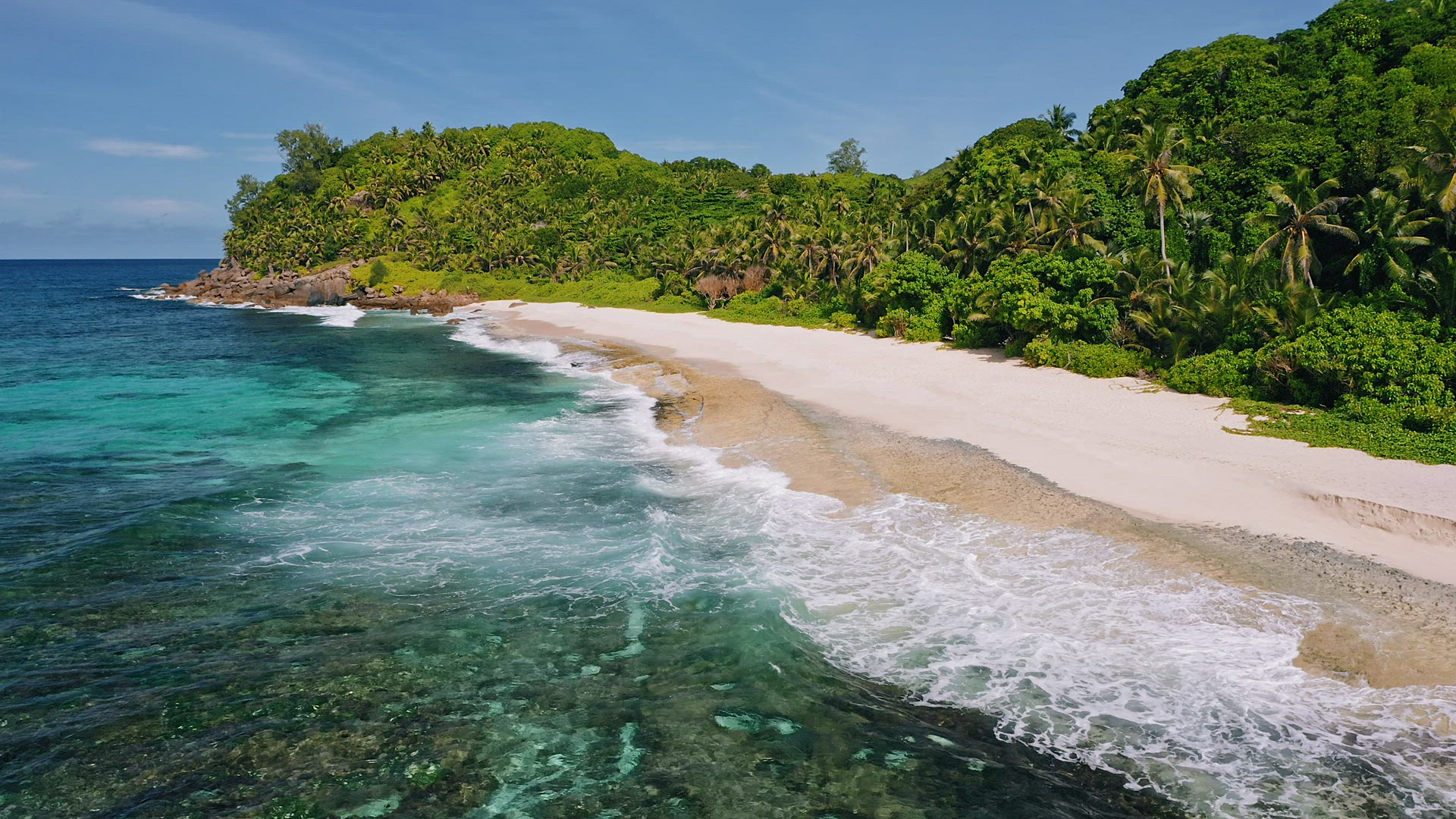 Mahe island, Seychelles. Aerial view of ocean waves rolling to white sand paradise like tropical bea