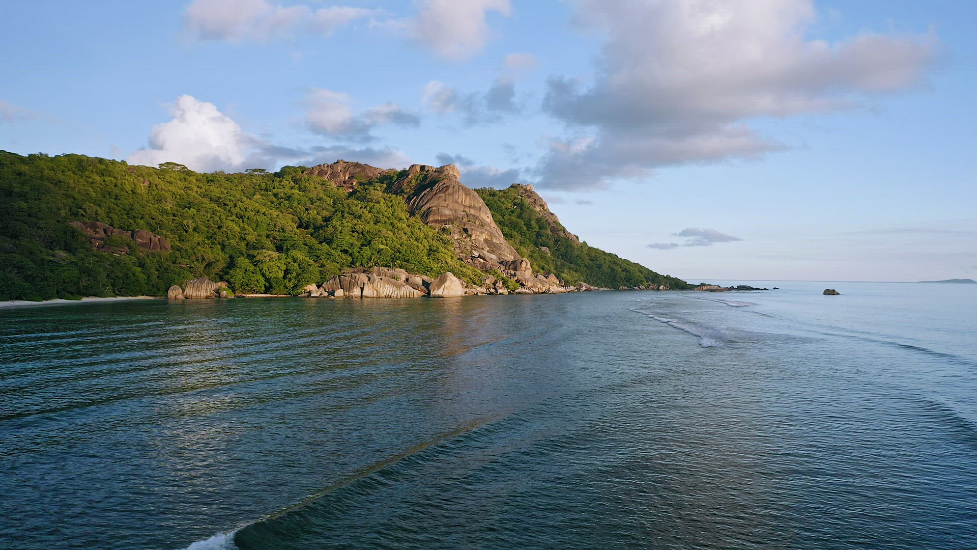 Aerial footage of famous tropical beach Anse Source d'Argent at sunset evening soft light. Calm wave