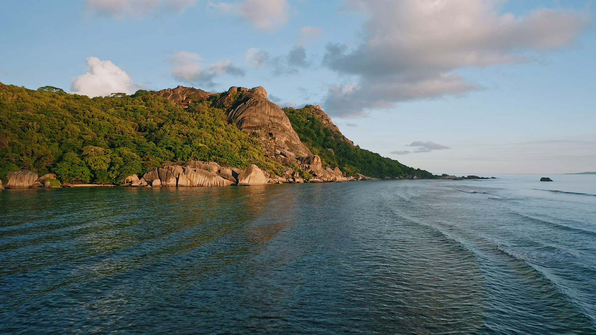 Aerial footage of famous tropical beach Anse Source d'Argent at sunset evening soft light. Calm wave