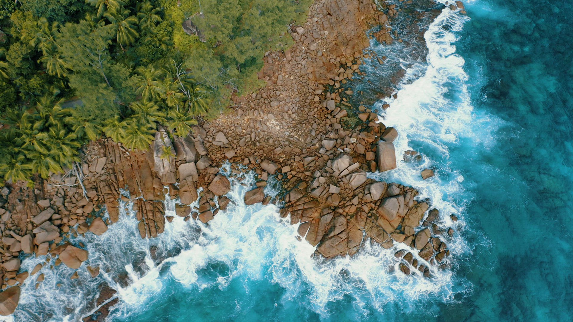 Aerial drone 4k stable footage over granite boulders near to Anse Bazarca beach. Ocean waves breakin