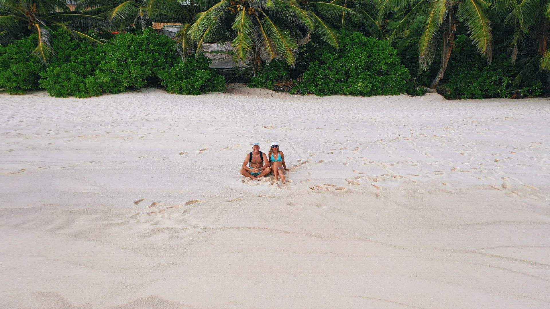 Seychelles tropical island luxury vacation. Happy adult couple on sandy beach with palm trees at Mah