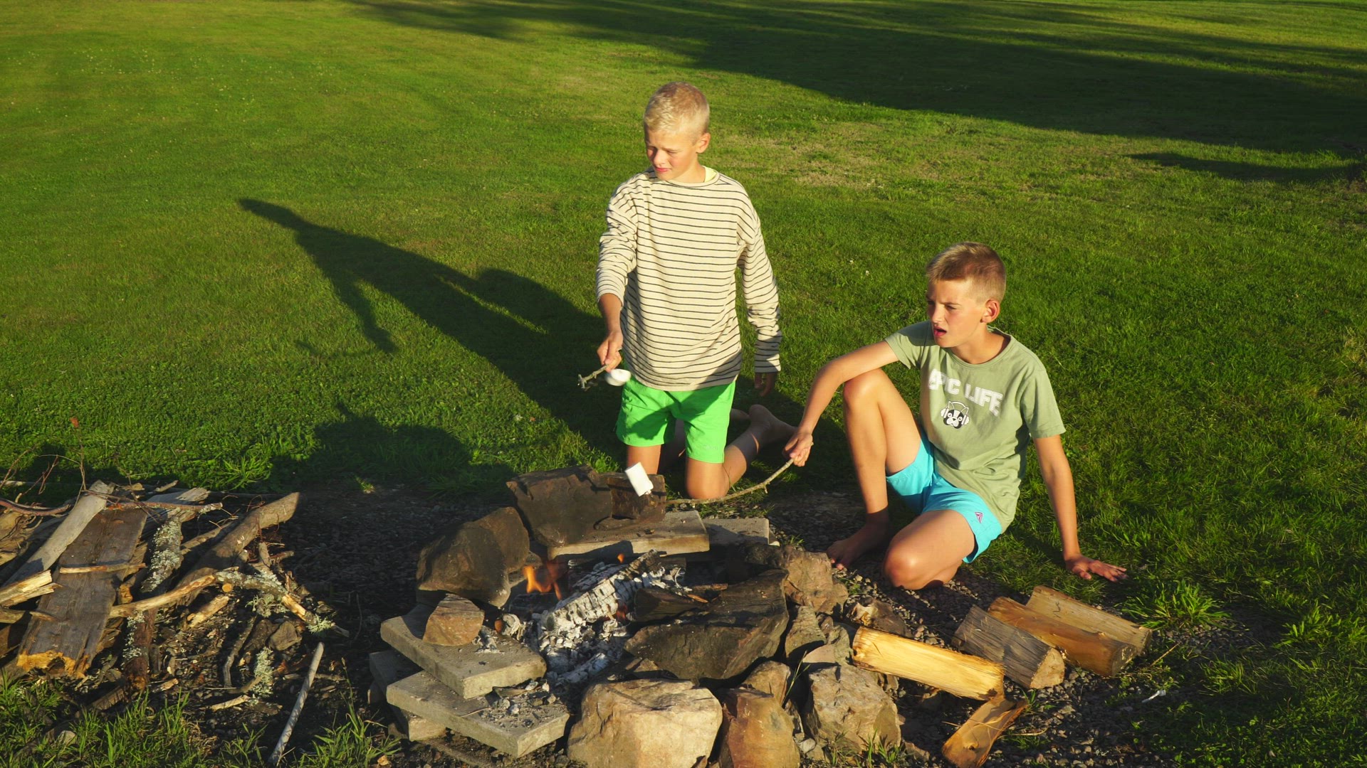 boys grilling marshmallows over open fire