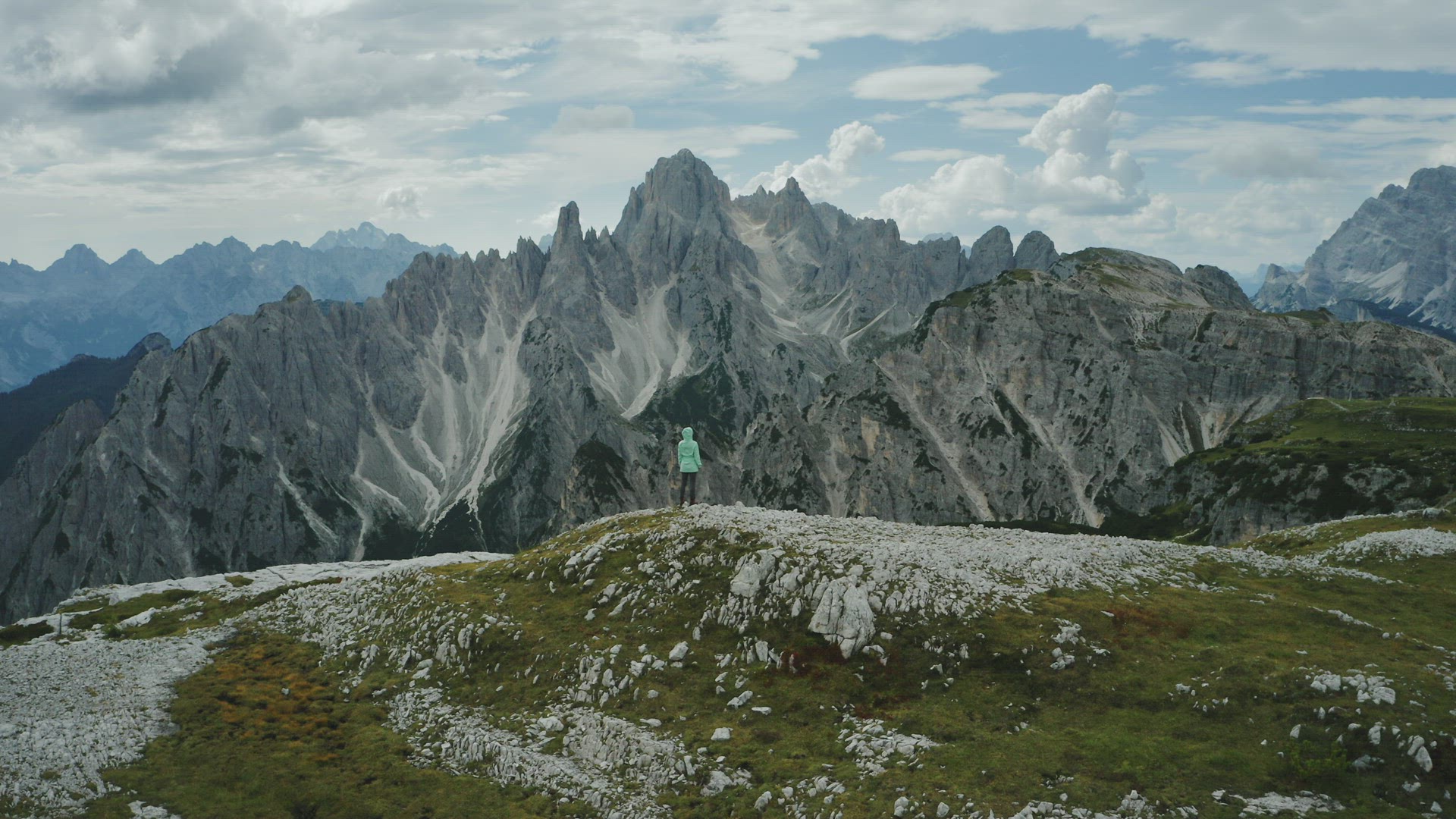 Aerial view of women hiking admiring Auronzo di Cadore of Cadini di Misurina mountains group in Dolo