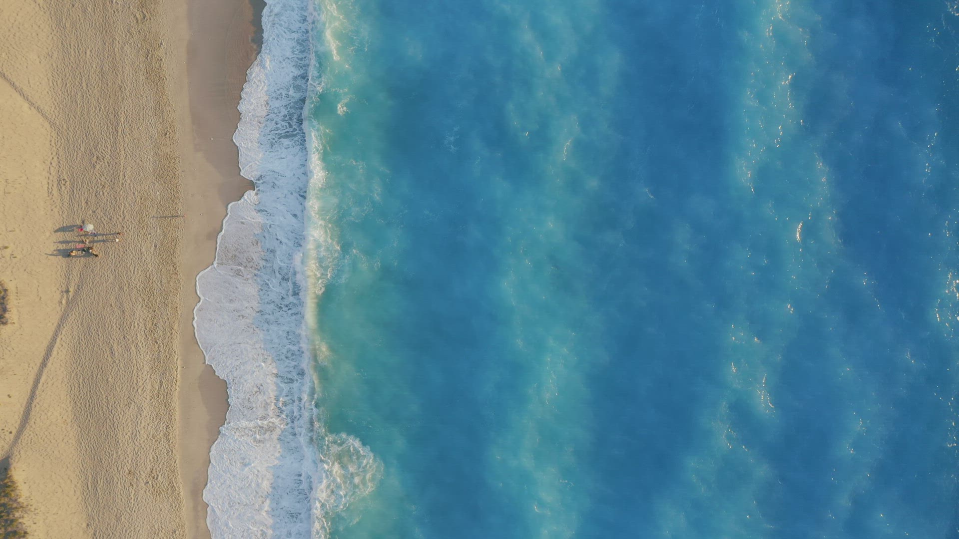 Milos beach, Lefkada, Greece. Top down view of golden sand and fluorescent, turquoise sea waves. Unr