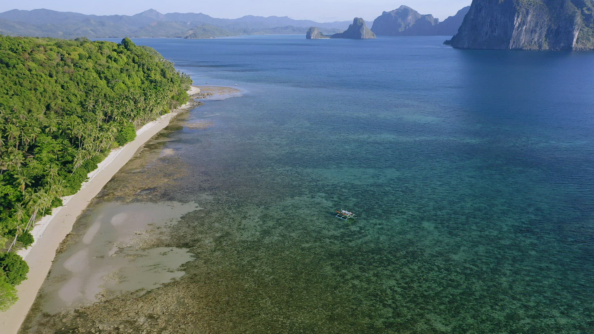 4k Aerial view of El Nido, Palawan, Philippines. Banca boat swimming in shallow water towards lonely