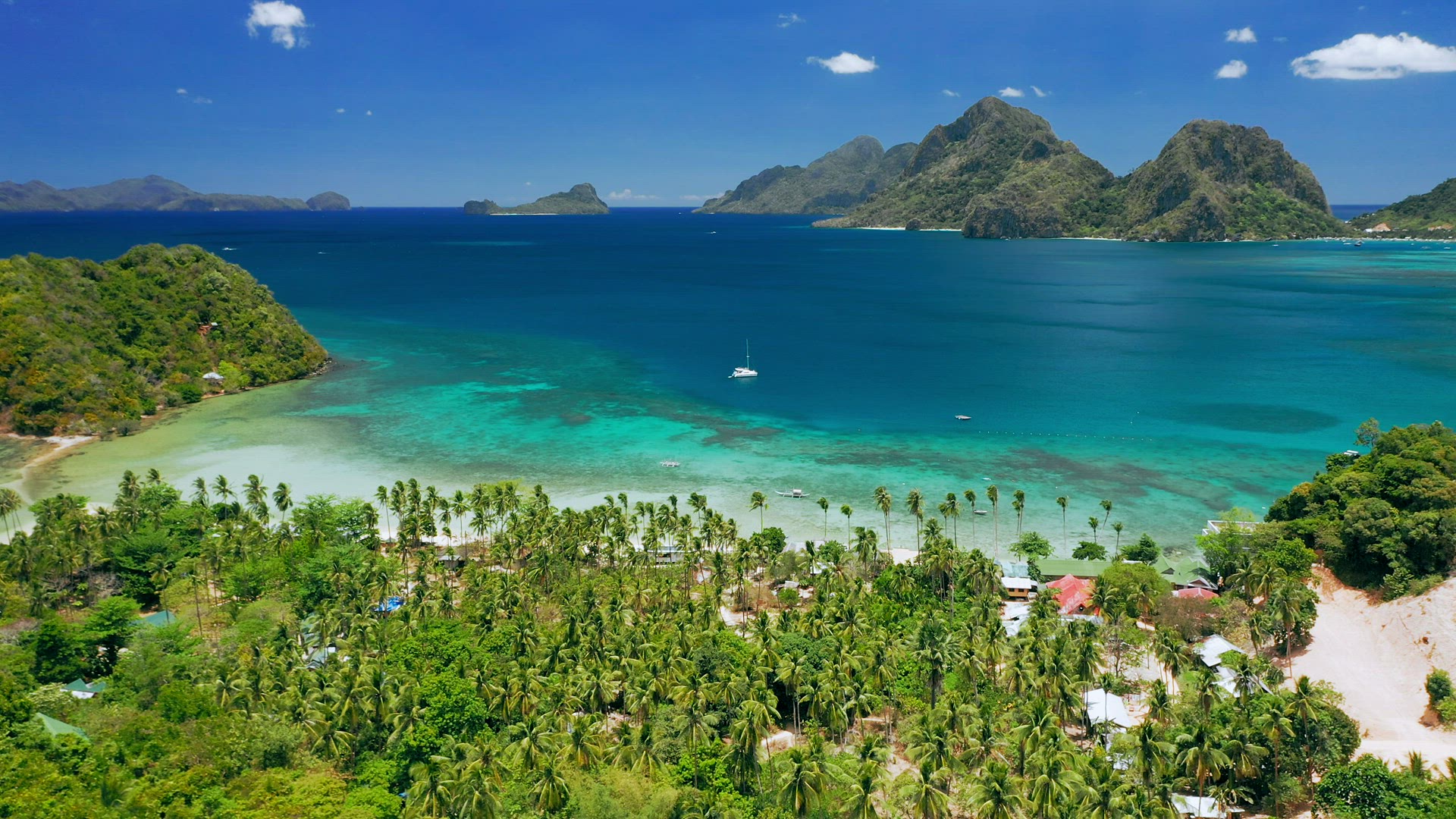 Aerial drone panoramic coastline view of Las Cabanas beach with sail boat in blue water, sandy beach