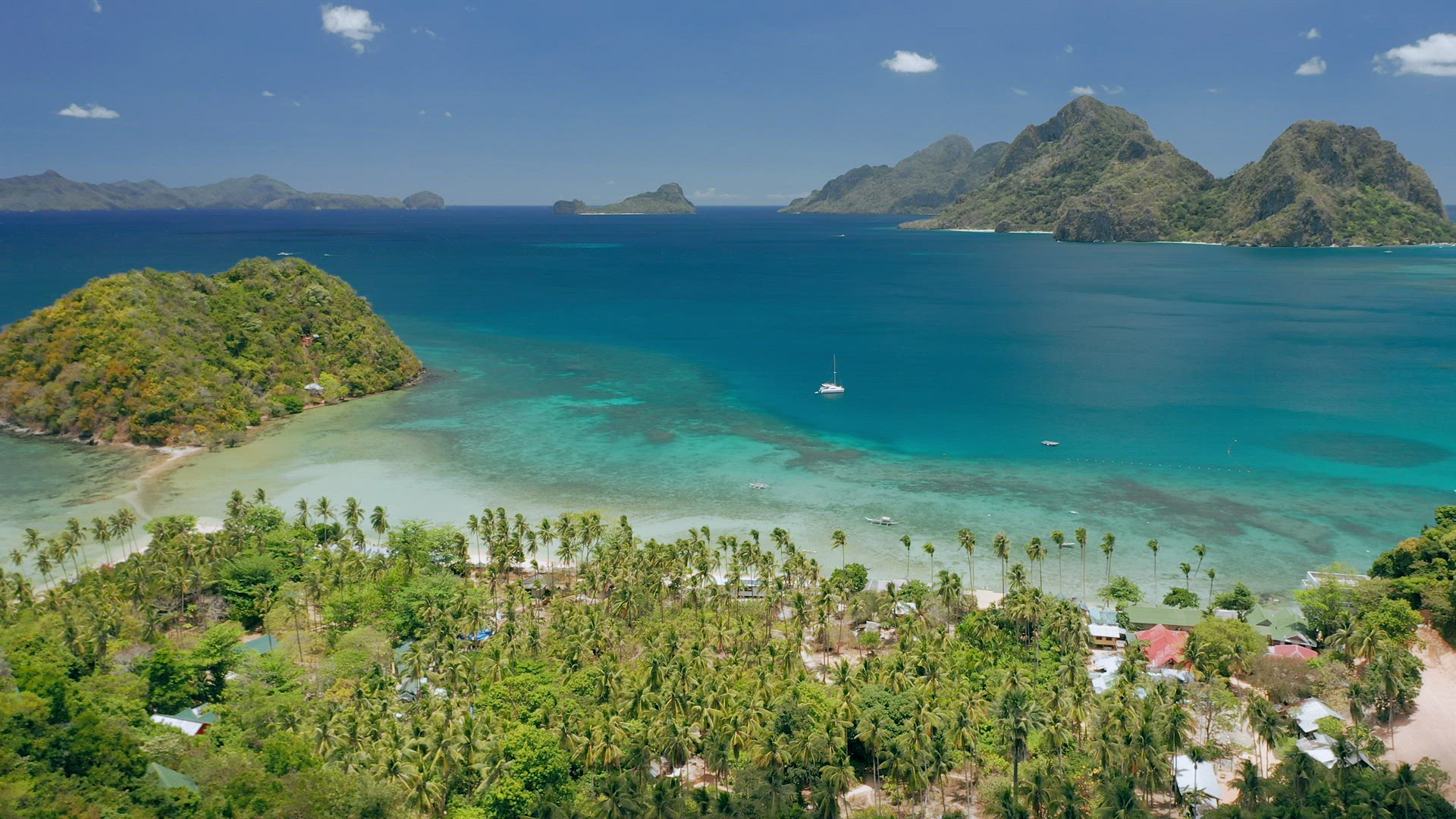 Aerial drone panoramic shot of Las Cabanas beach. El Nido, Palawan, Philippines. Lonely sail boat st