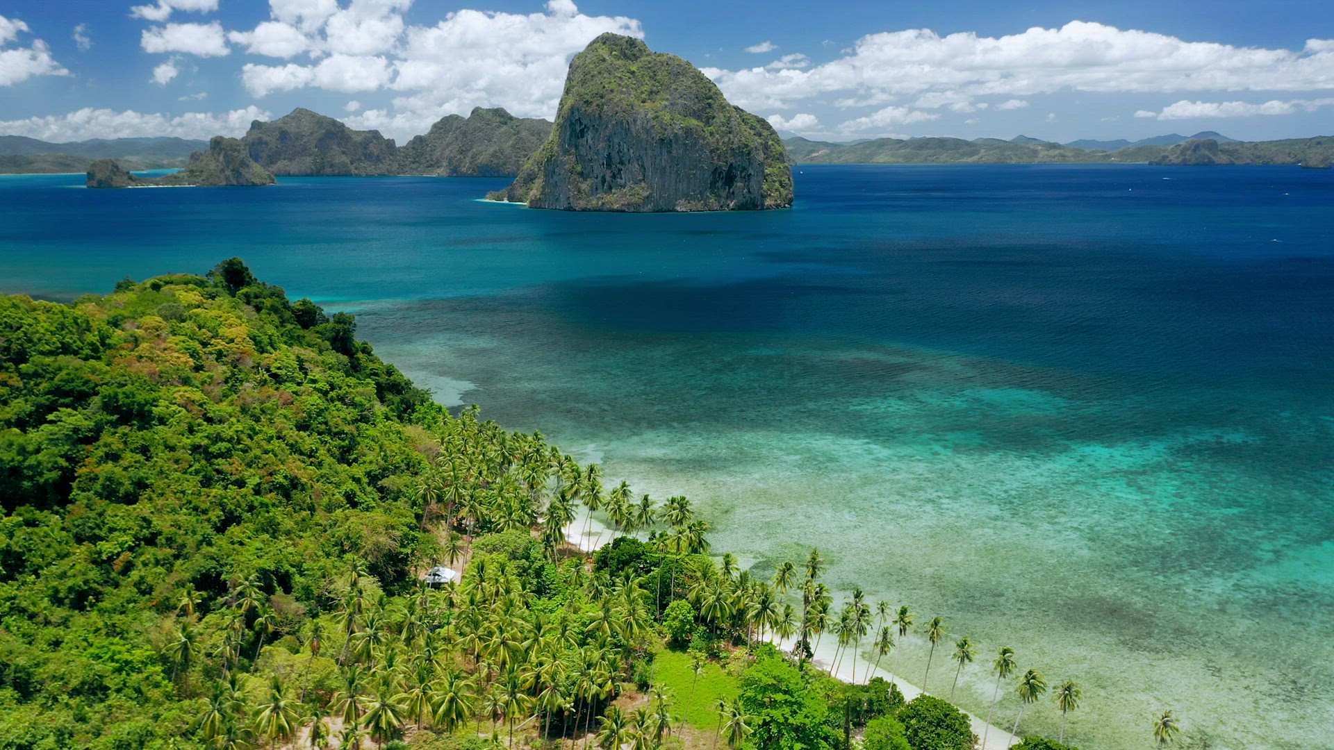Aerial drone shot of remote coastline of Bacuit bay. Green jungle, turquoise ocean, tropical islands