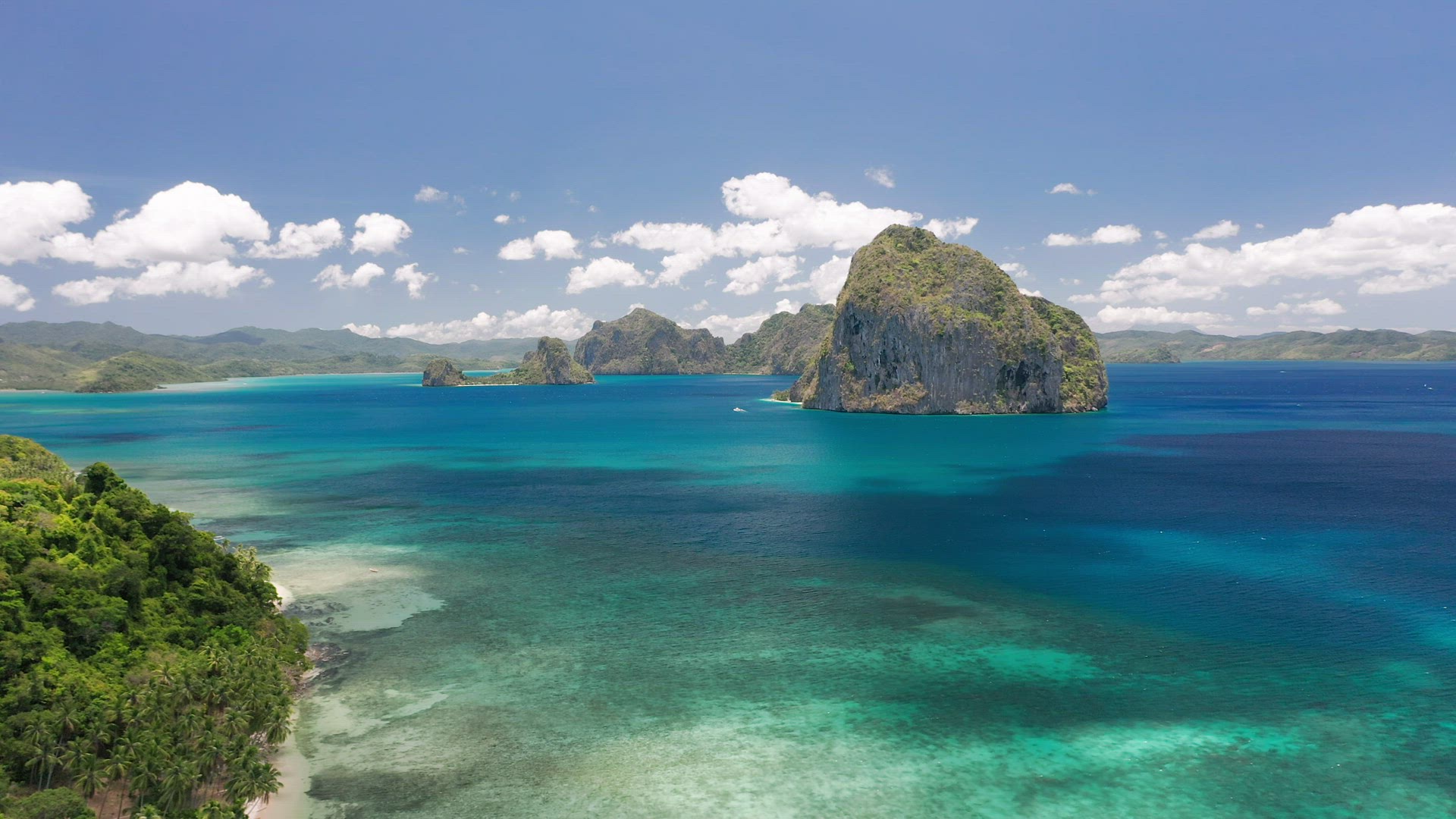Aerial drone view of Huge Pinagbuyutan island and clouds shadow moving on ocean surface. El Nido, Pa