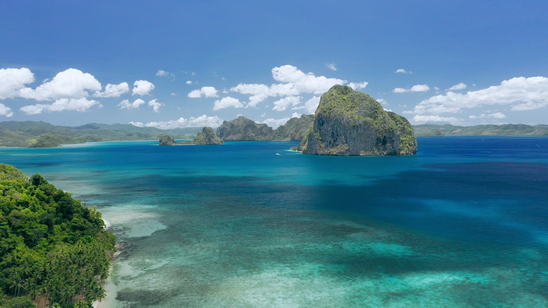 Aerial drone view of Huge Pinagbuyutan island and clouds shadow moving on ocean surface. El Nido, Pa
