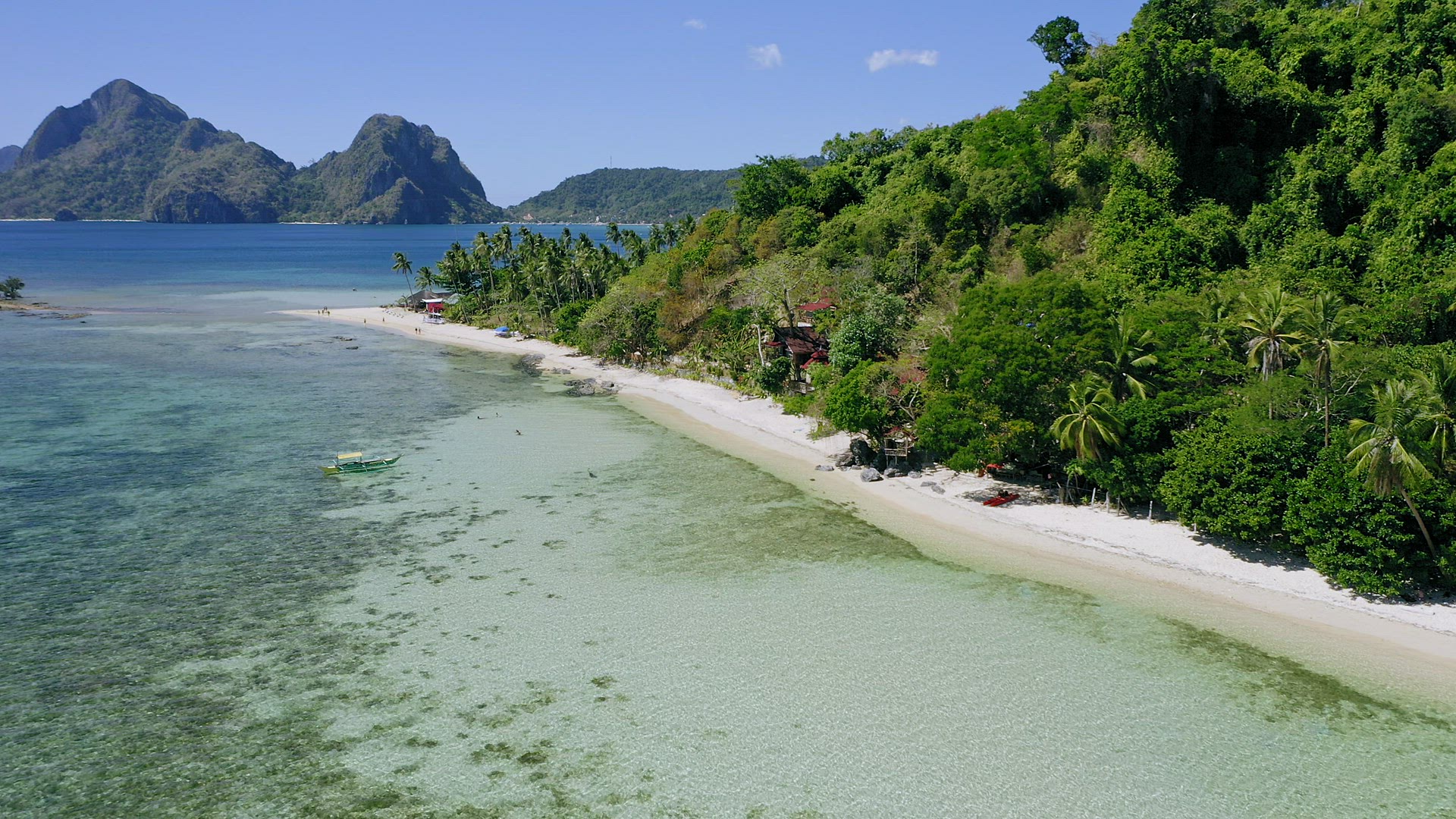 4k Aerial drone circle fly around tropical sandy beach with local boats in shallow water and coconut