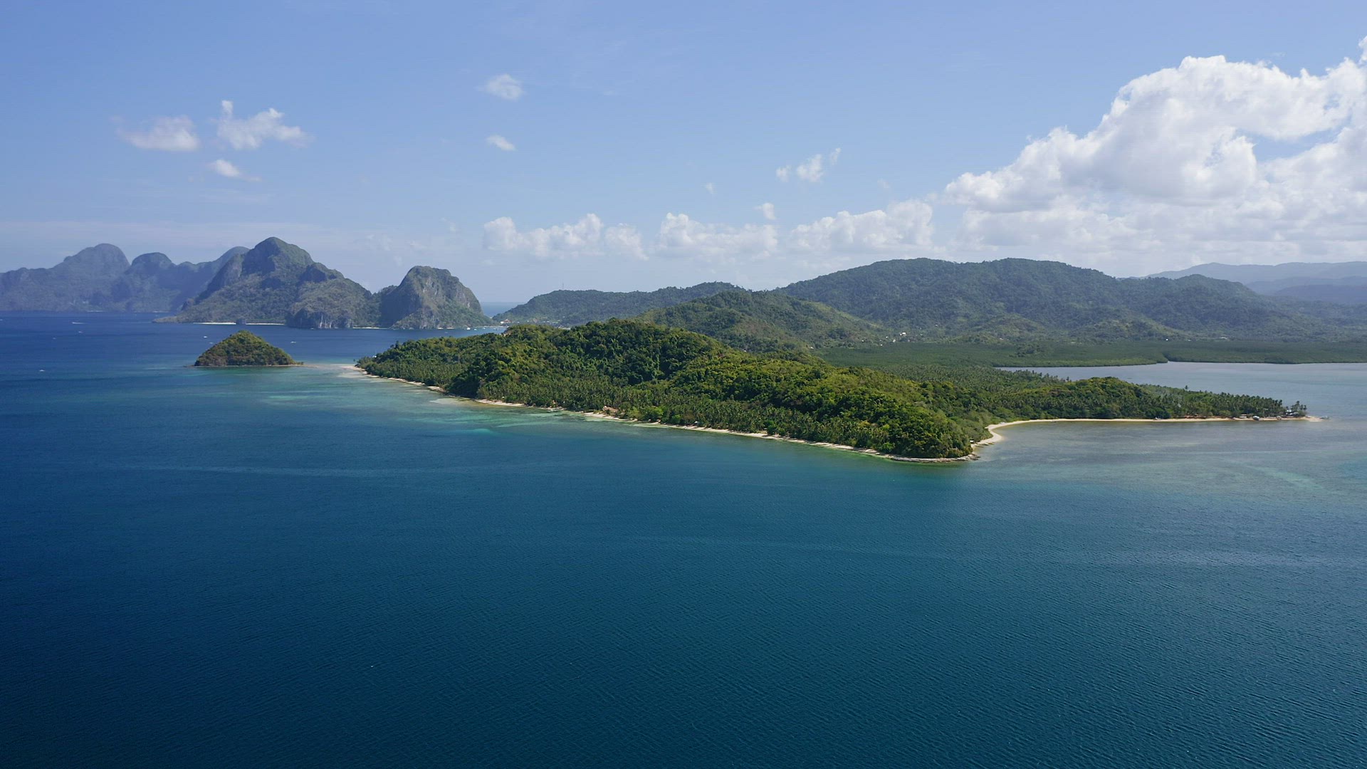 4K Aerial high attitude drone fly over ocean towards a El Nido mainland with towering limestone kars