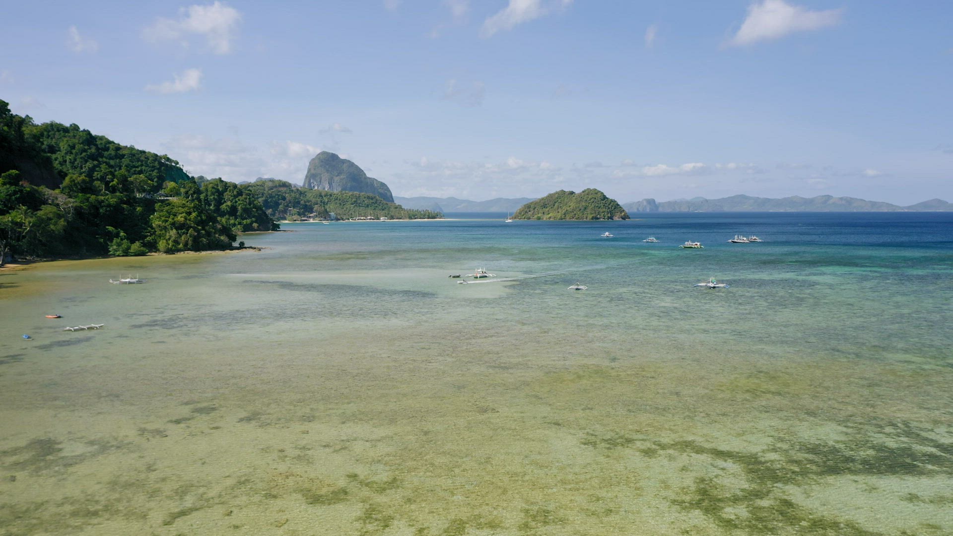 El Nido, Palawan island, Philippines - 4K Aerial drone view of boats anchored in the bay with clear 