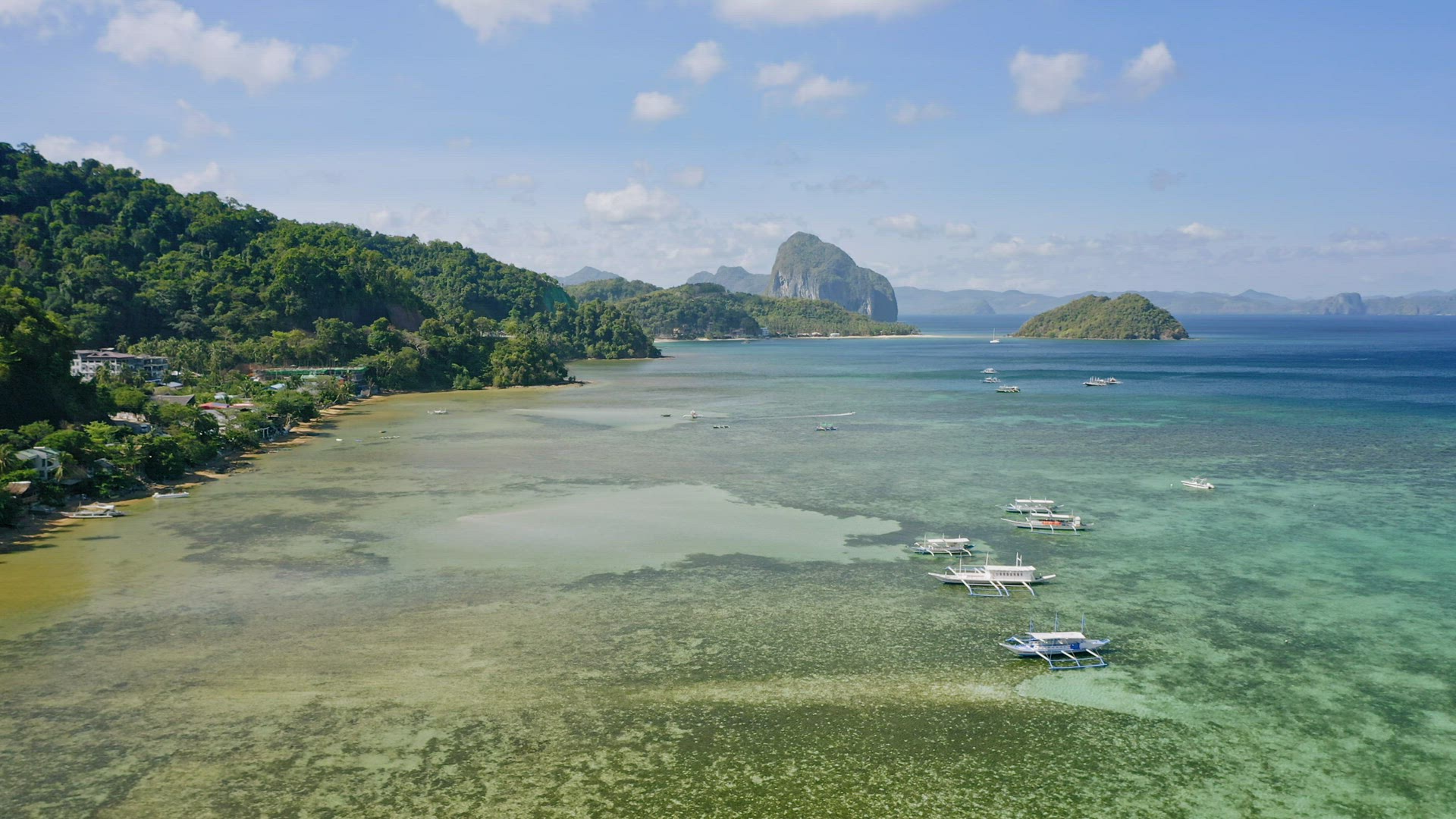 El Nido, Palawan island, Philippines - 4K Aerial drone view of boats anchored in the bay with clear 