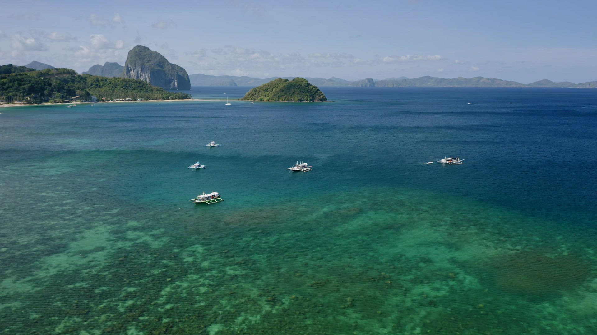 El Nido, Palawan island, Philippines - 4K Aerial drone view of boats anchored in the bay with clear 