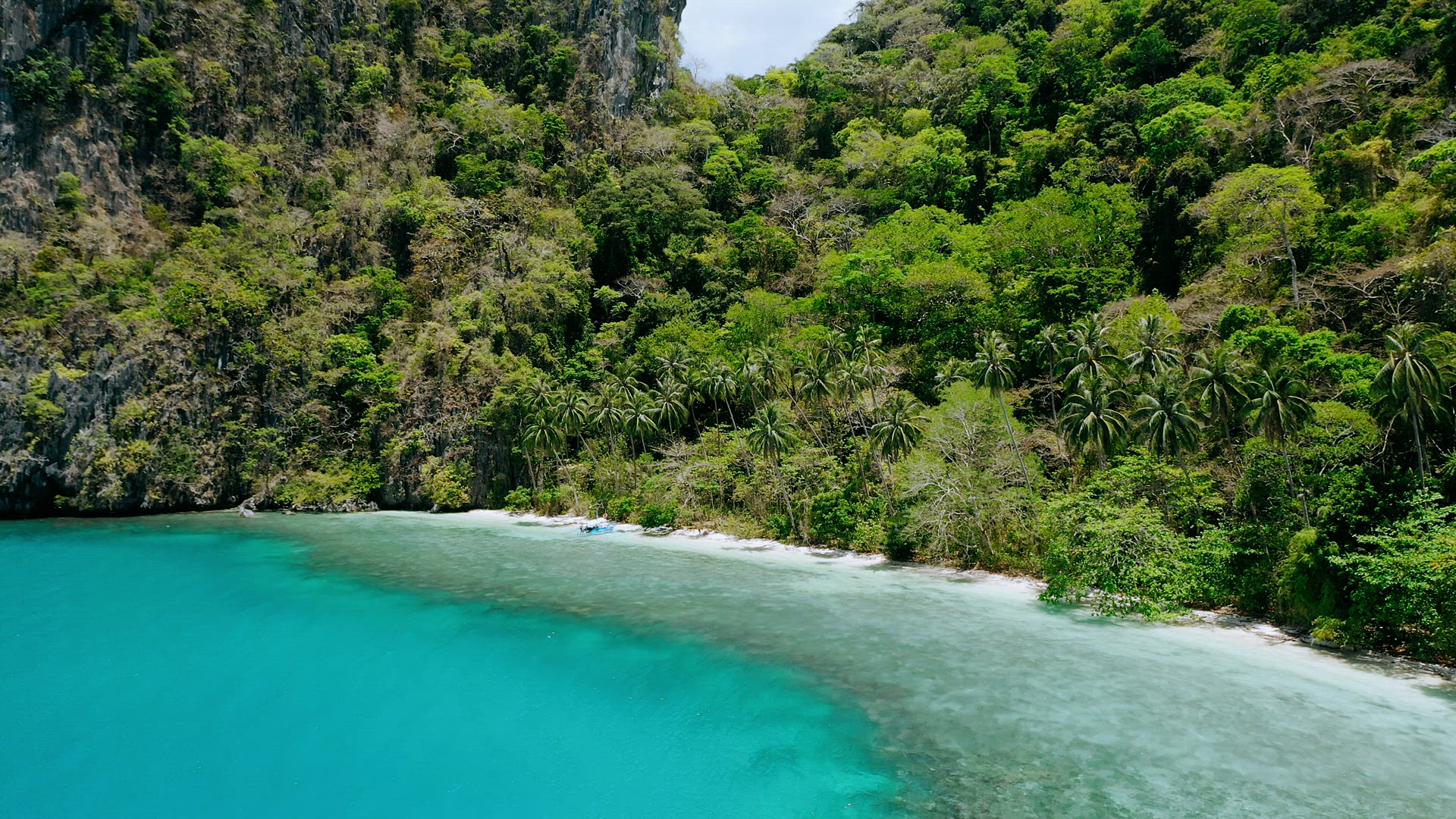 4k drone aerial circle movement around blue lagoon and secluded paradise beach with palm trees swayi