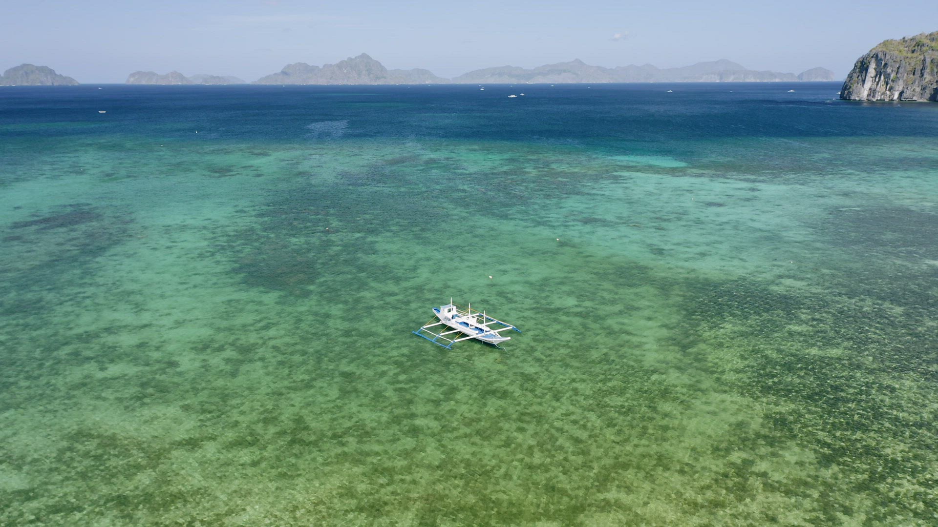 Aerial view of Filipino boats moored in shallow lagoon bay near El Nido village. Bacuit Bay, Palawan