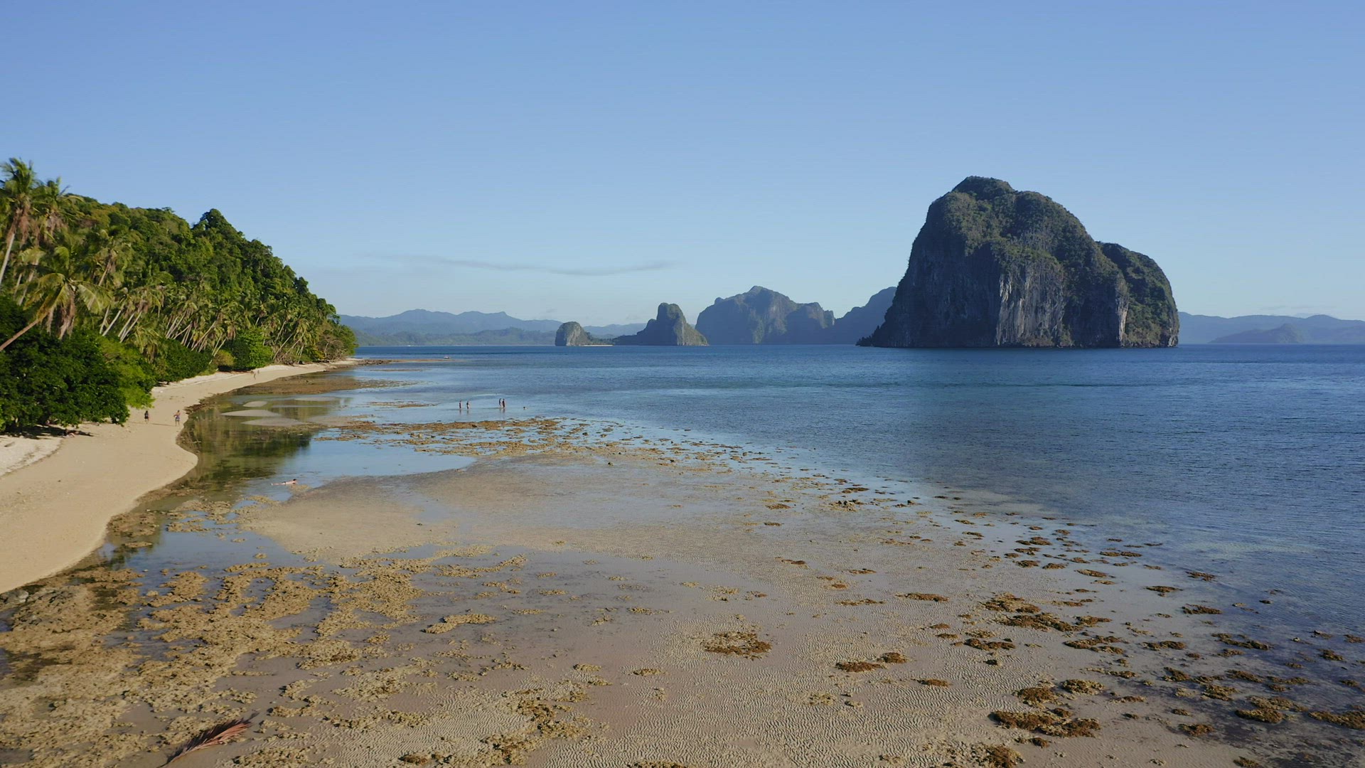 4k Aerial fly along tropical beach of El Nido village, Palawan, Philippines. Tourists relax and expl