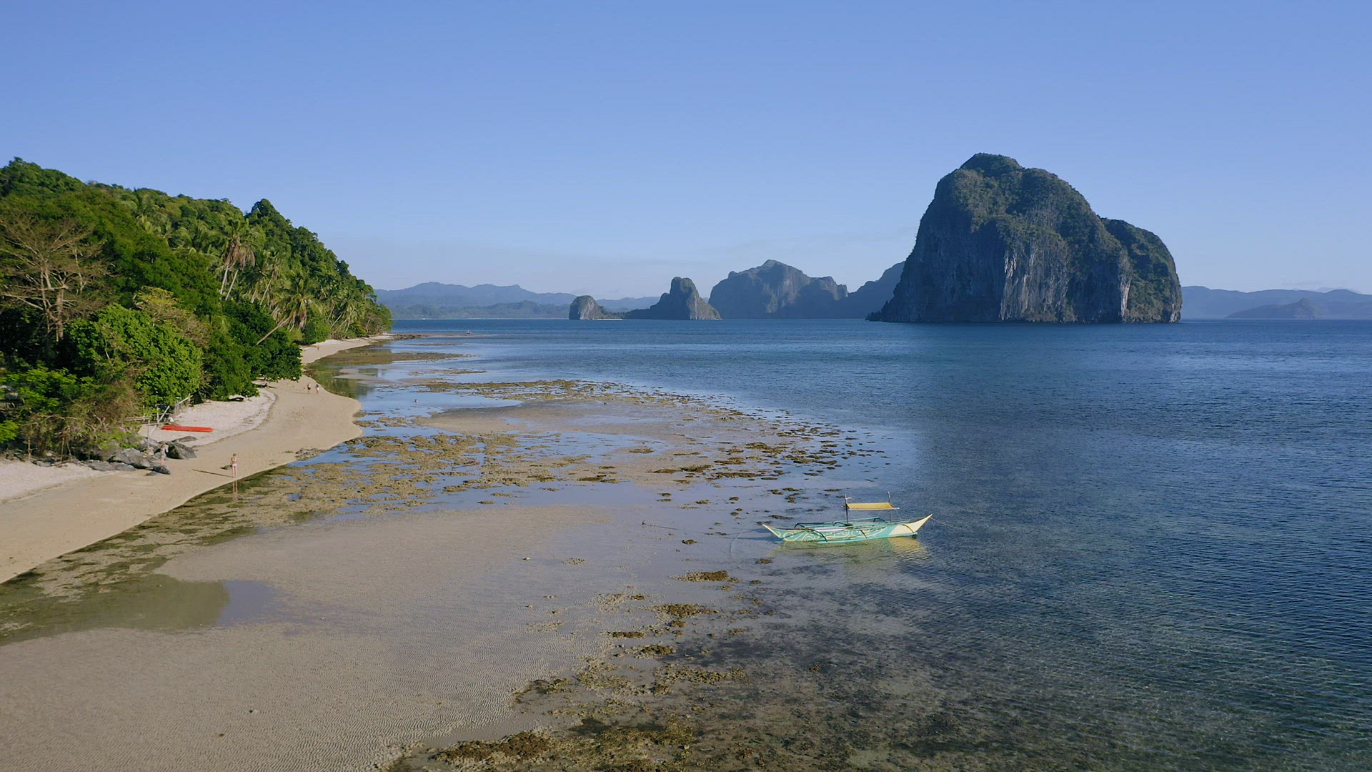 4k Aerial view of El Nido, Palawan, Philippines. Banca boat moored in shallow water during low tide.