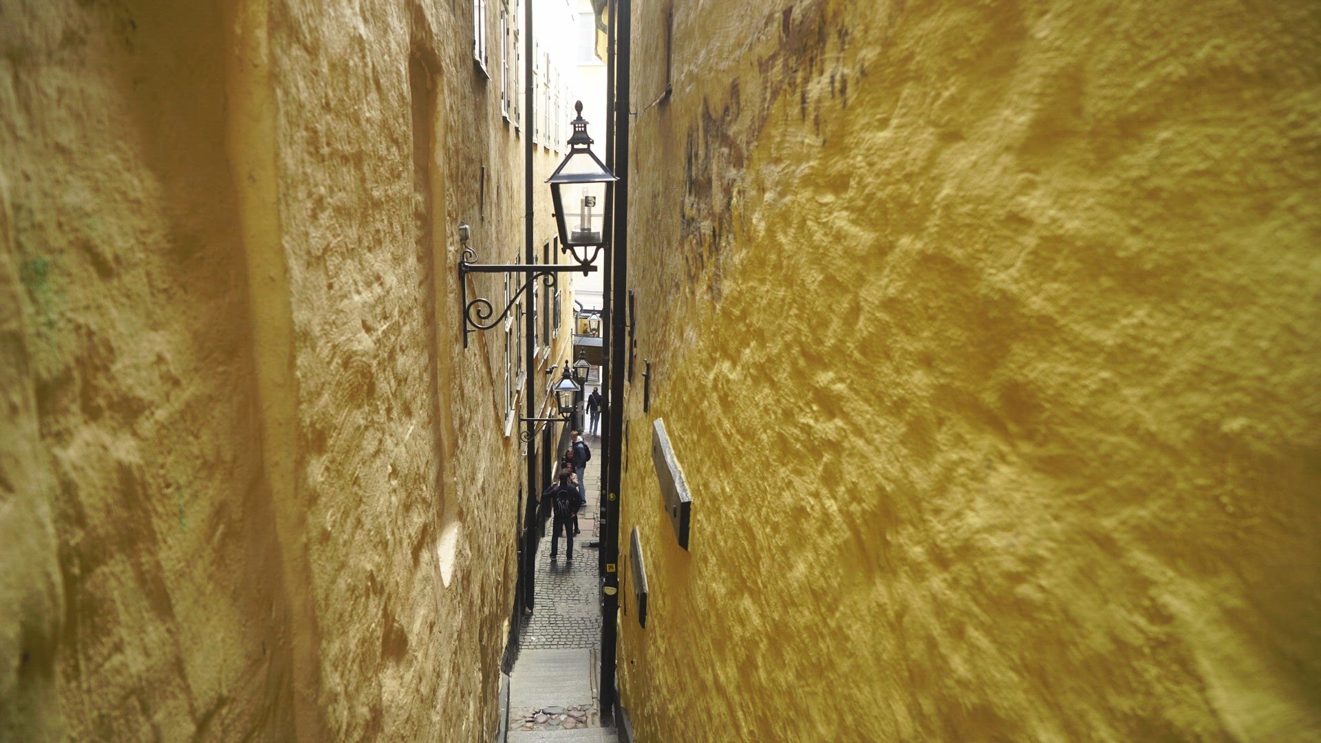 tourists walking down stairs on narrow street in old town, Stockholm