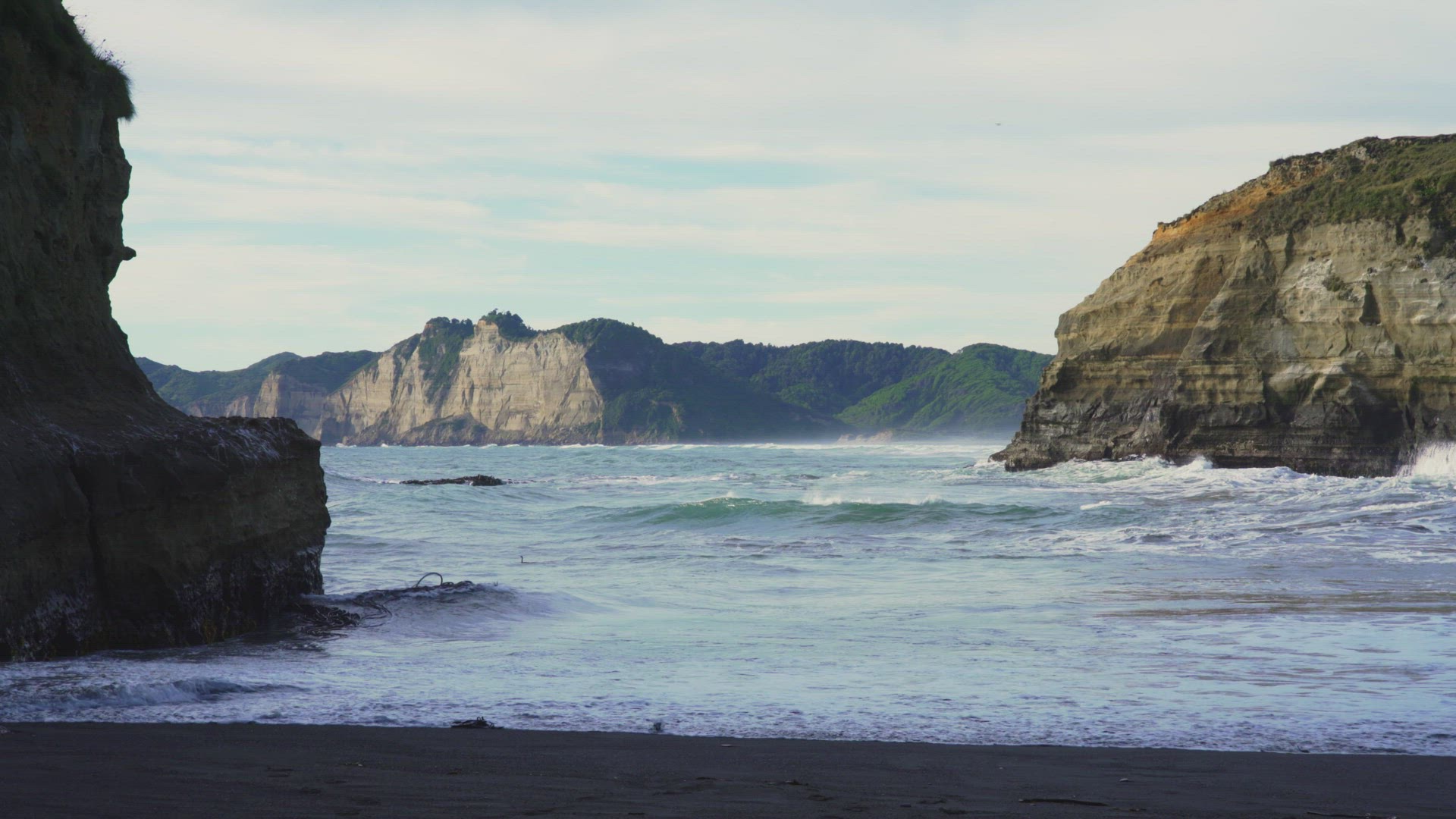 View Of Pacific Ocean Waves Breaking Onto Small Beach