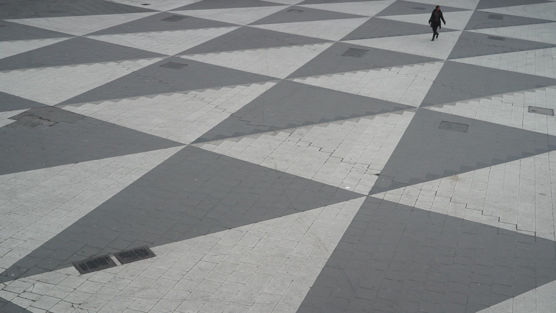 two persons crossing sergels torg in stockholm - one talking in mobile phone - pandemic
