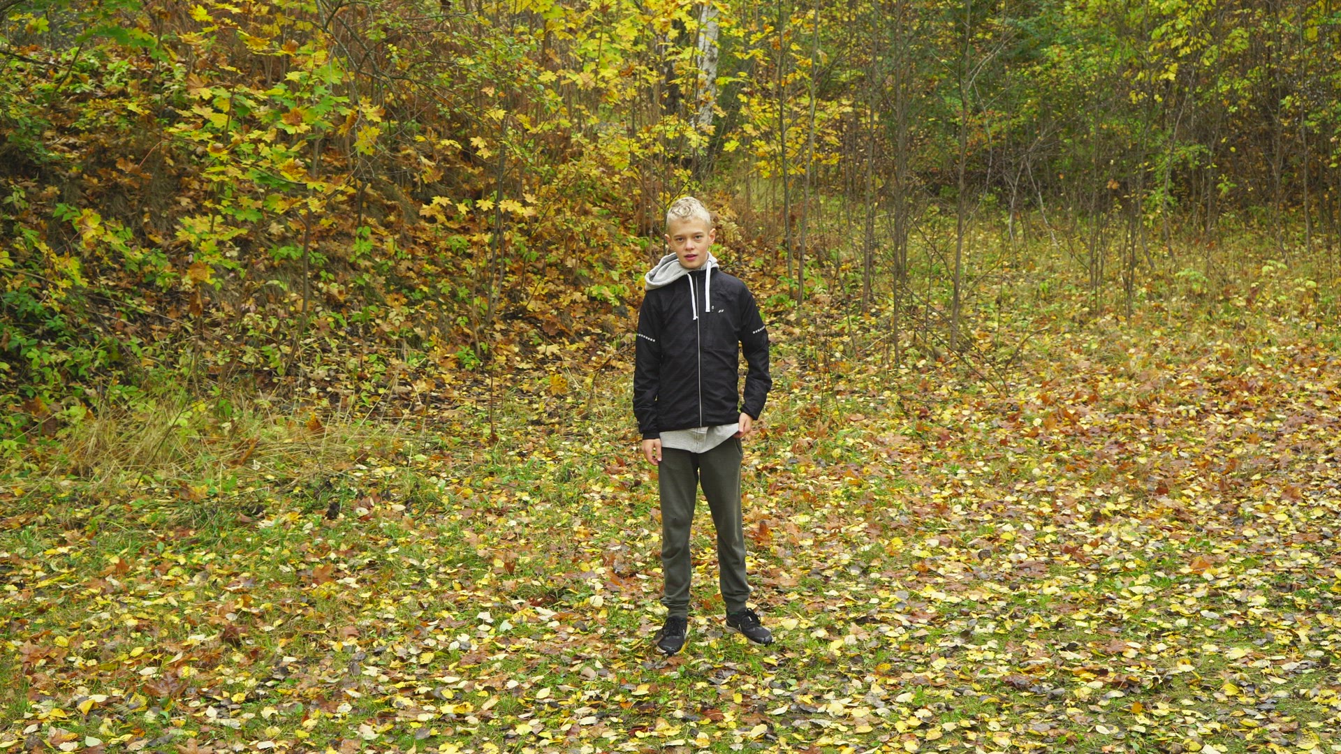 boy making high kick - autumn leaves on ground