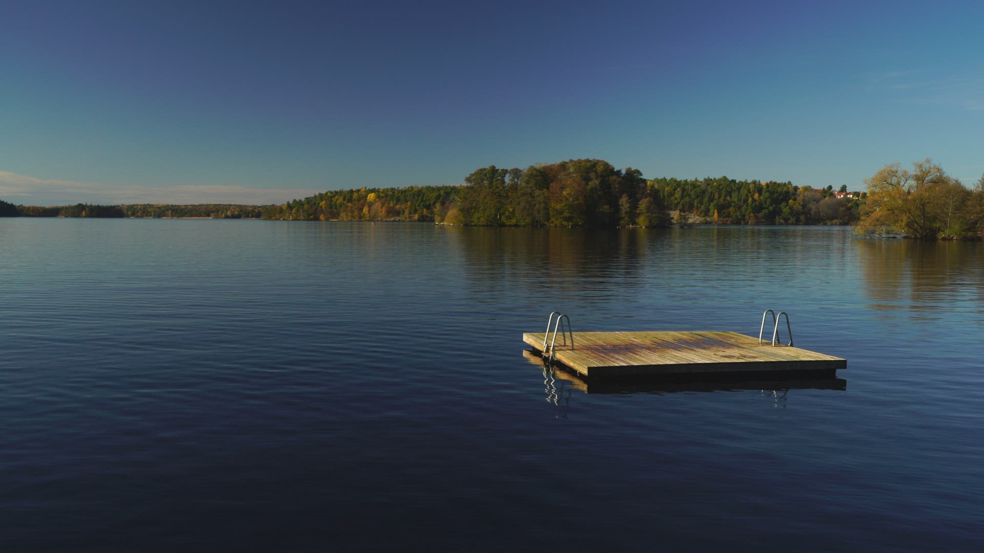 lake with floating jetty - gloassy surface - autumn landscape and colours